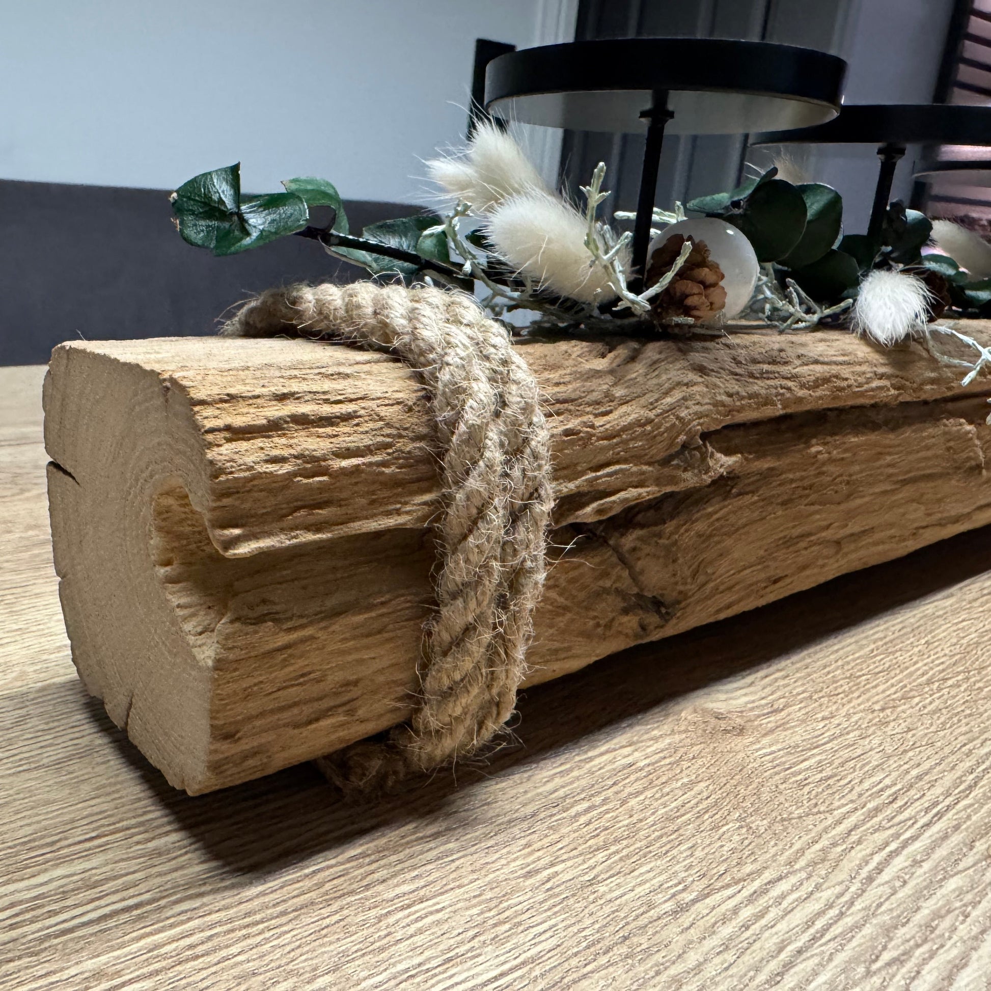 Treibholz Adventskerzenhalter mit vier brennenden Kerzen und Glaszylinder im skandinavischen Weihnachtsambiente.