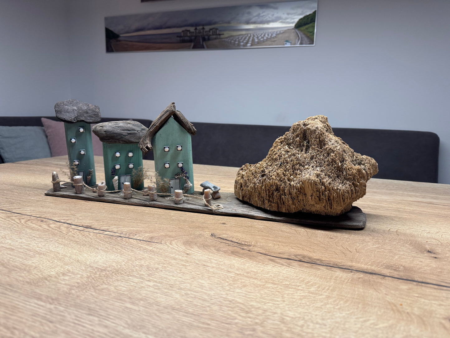 Handgemachtes Treibholz-Dorf mit Fossil und Zaun aus Donnerkeilen, 57×18×14 cm.