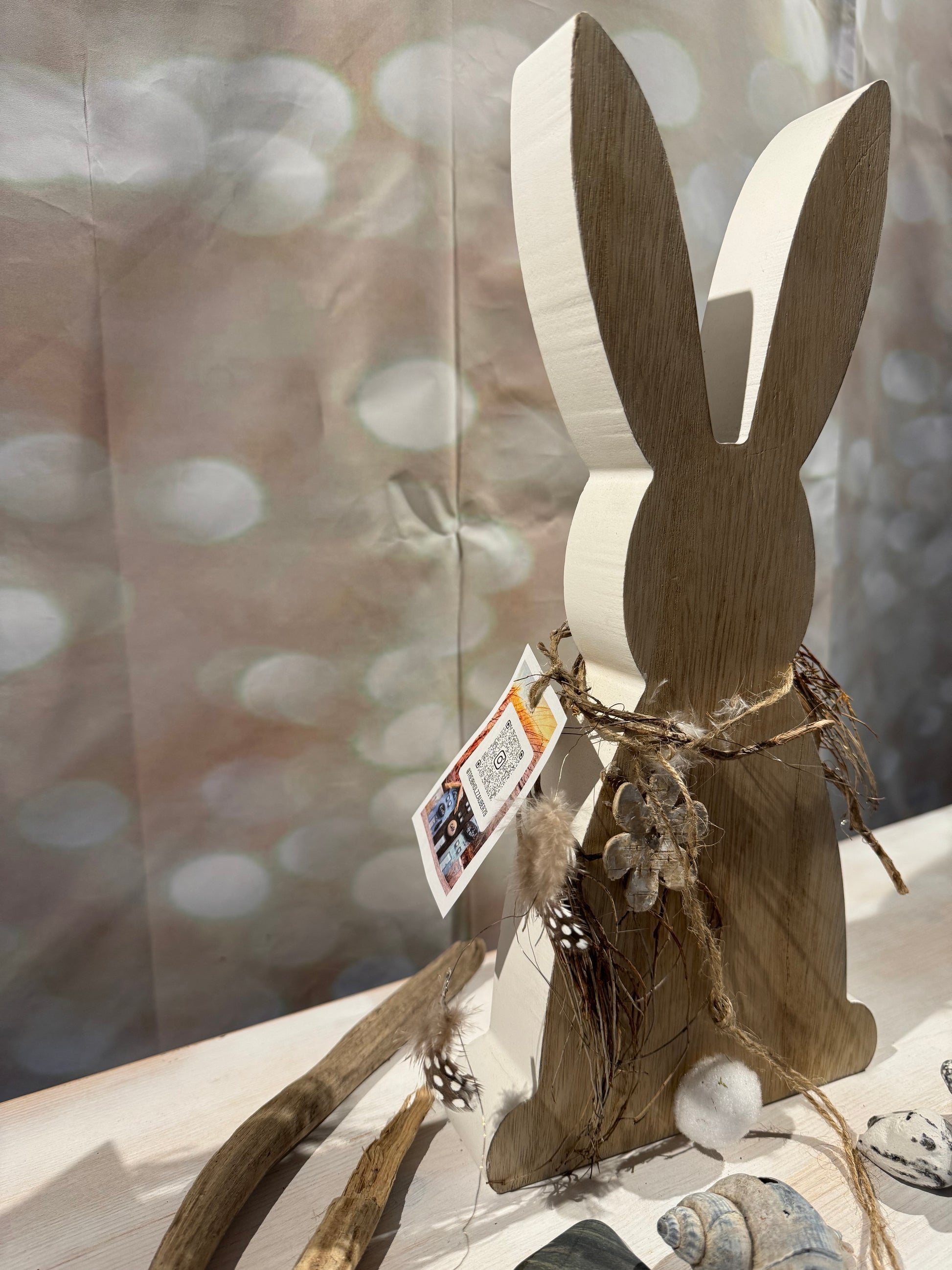 Detailaufnahme Osterhase aus Holz mit Naturband, Trockenmaterialien und Blütendekoration