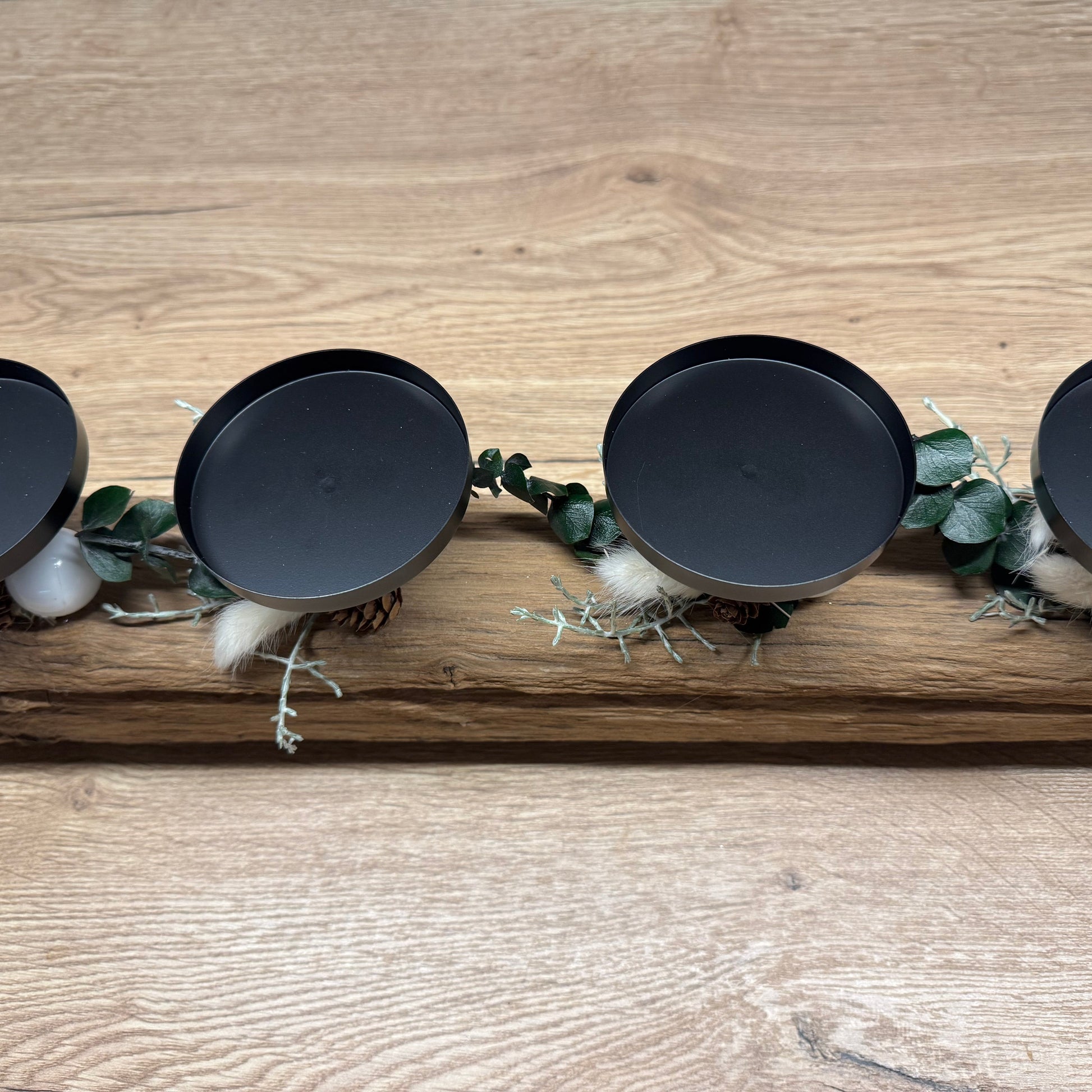 Adventskerzenhalter aus Eichenholz mit vier brennenden Kerzen und Glaszylinder im skandinavischen Weihnachtsambiente.