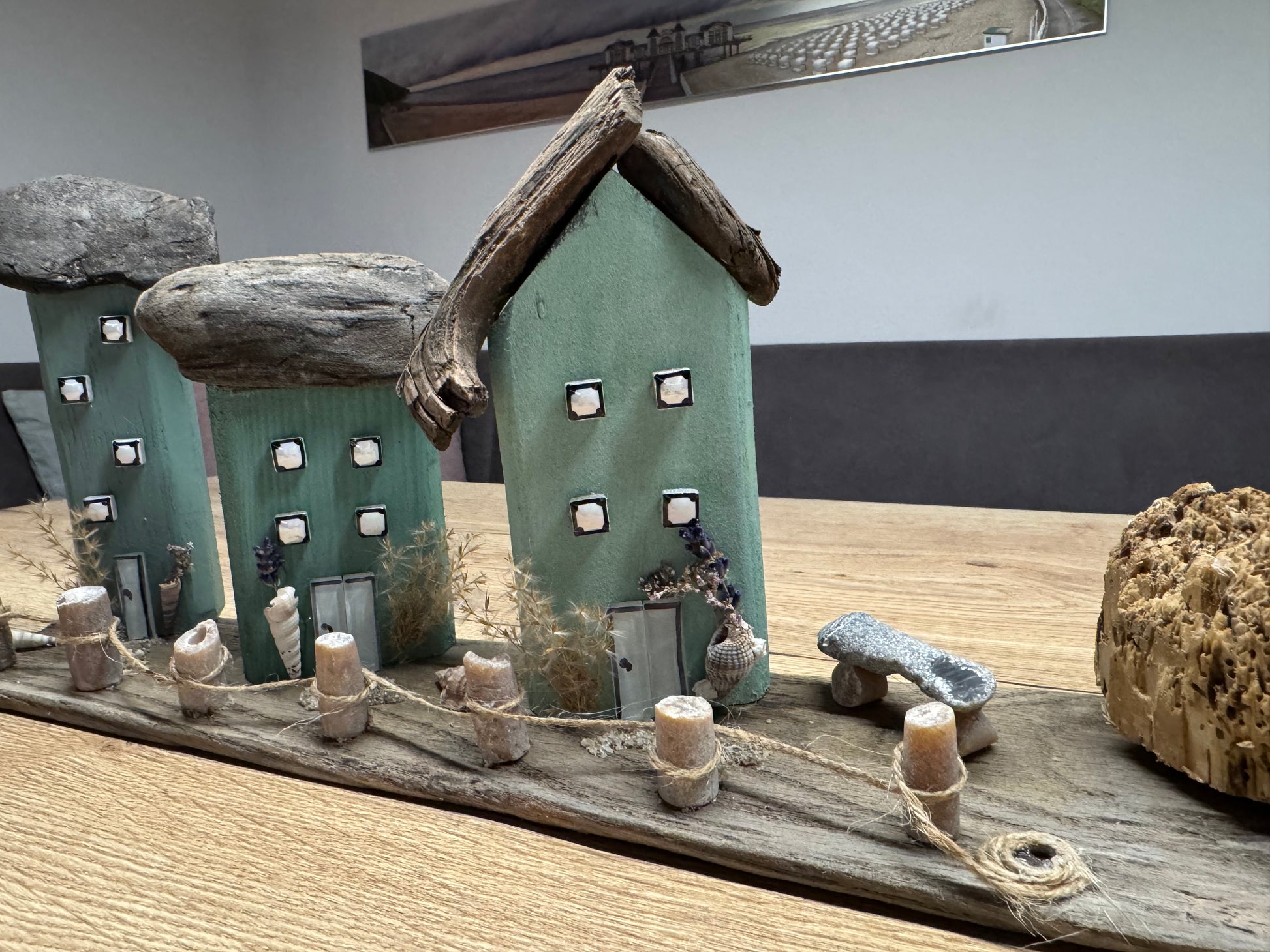 Detailbild der Häuser und des Donnerkeil-Zauns mit Muscheln und Naturmaterialien.