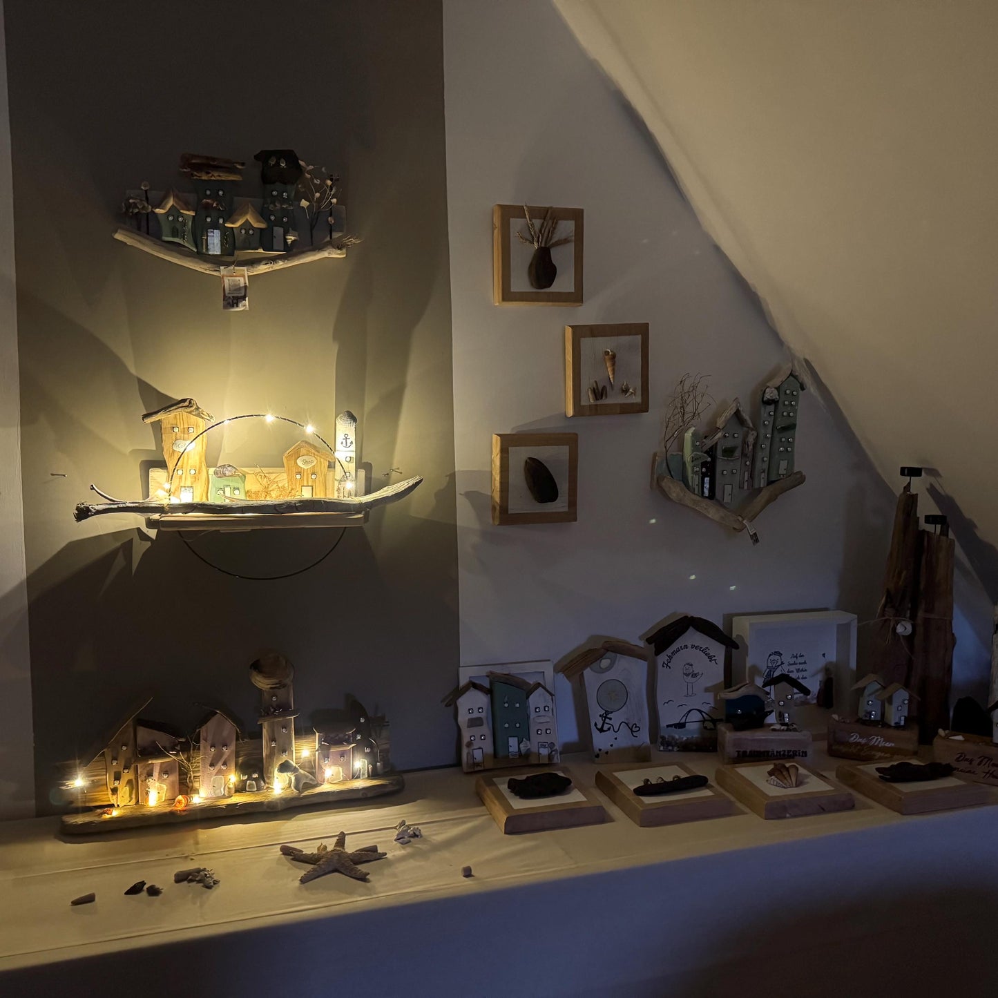 Ausstellung handgefertigter Holzkunstwerke von Küstendörfern. Es umfasst beleuchtete Wandbehänge mit Miniaturhäusern