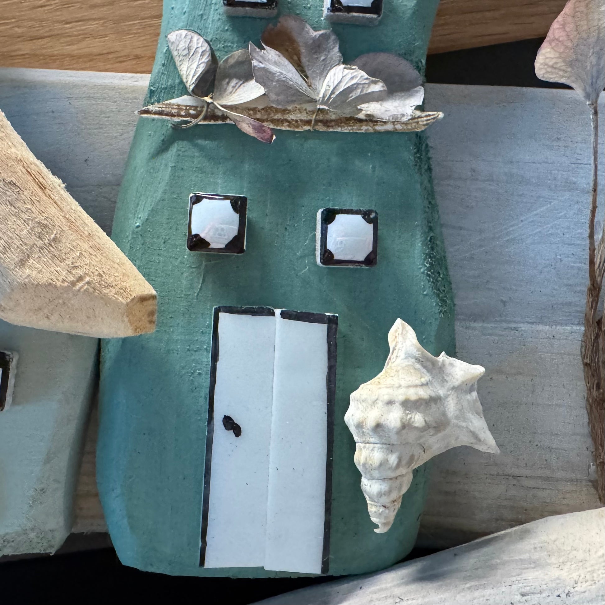 Detailansicht eine Muschel neben maritimer Haustür aus Holz von Treibholzzauber79