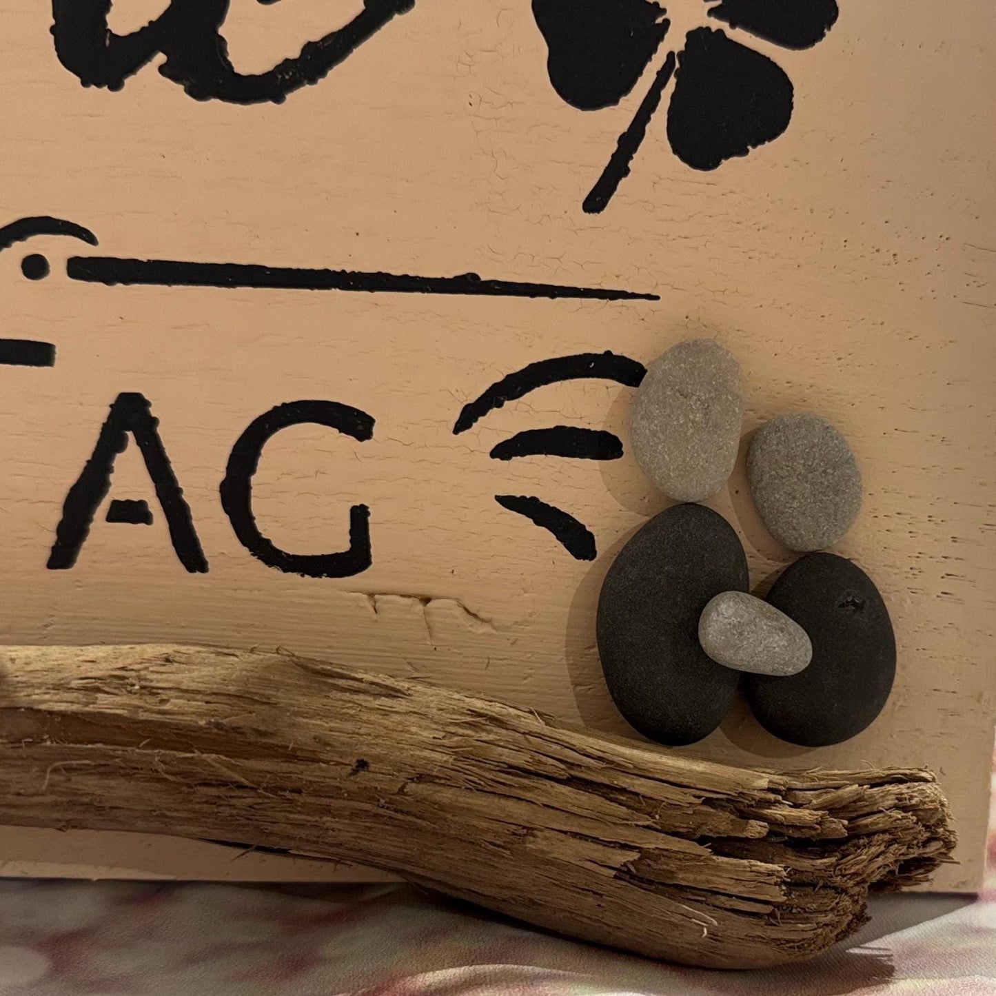 Detail mit Steinen und Muscheln auf handgefertigtem Holzschild, rustikale Deko aus Eichenholz