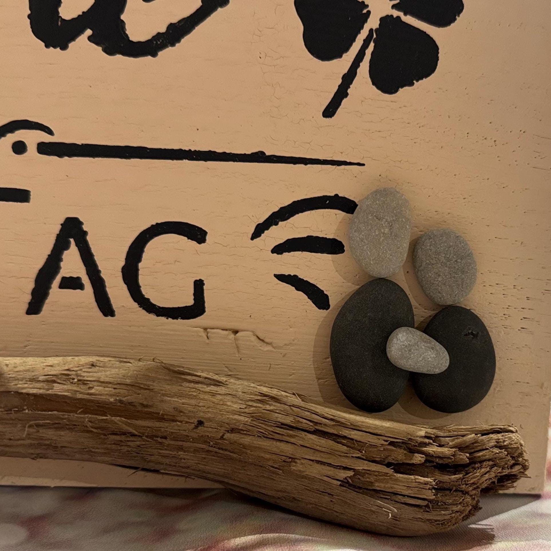Detail mit Steinen und Muscheln auf handgefertigtem Holzschild, rustikale Deko aus Eichenholz