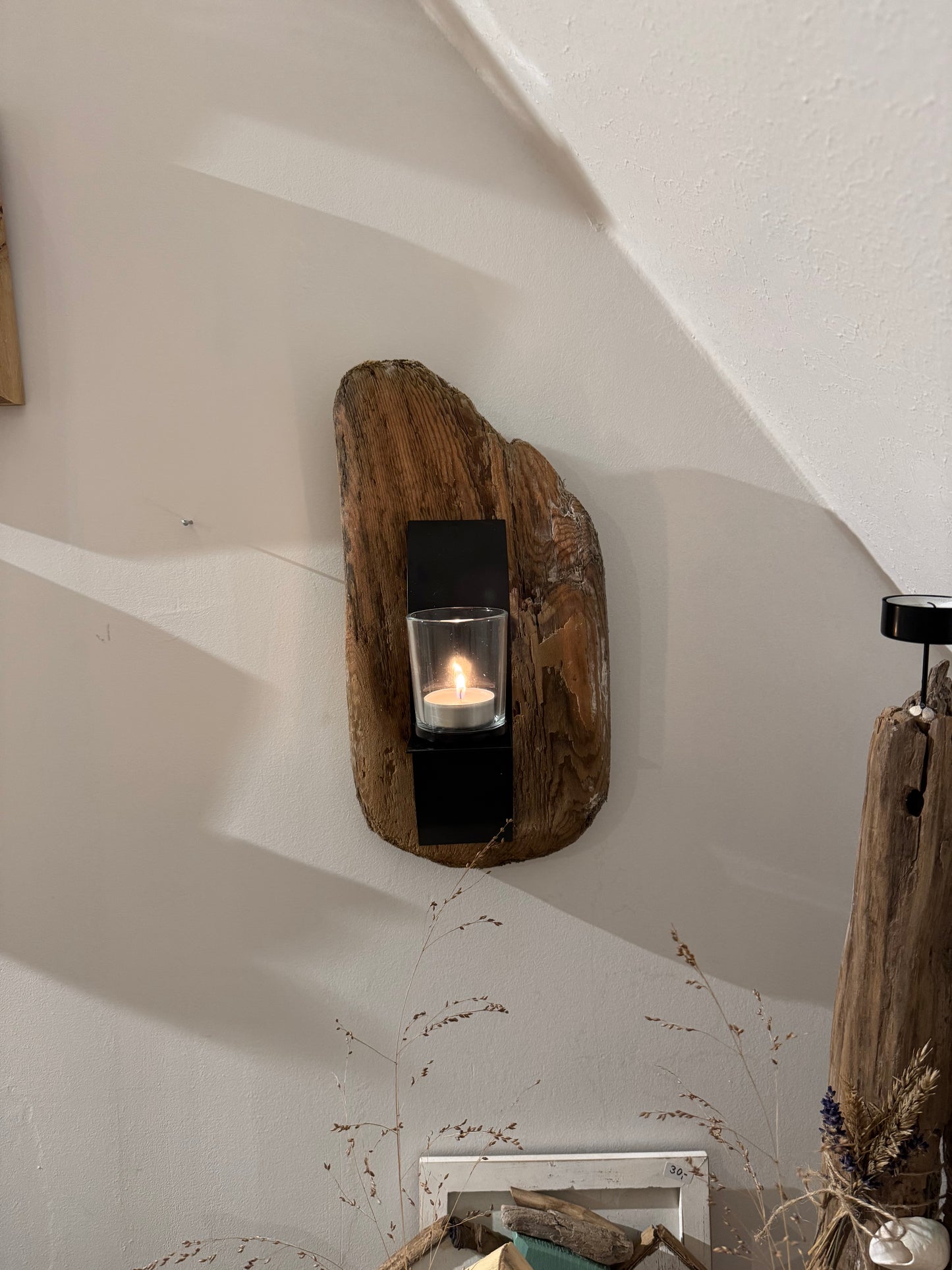 Detailansicht Treibholz Kerzenhalter an der Wand, rustikale Holzmaserung und Glas mit Kerze