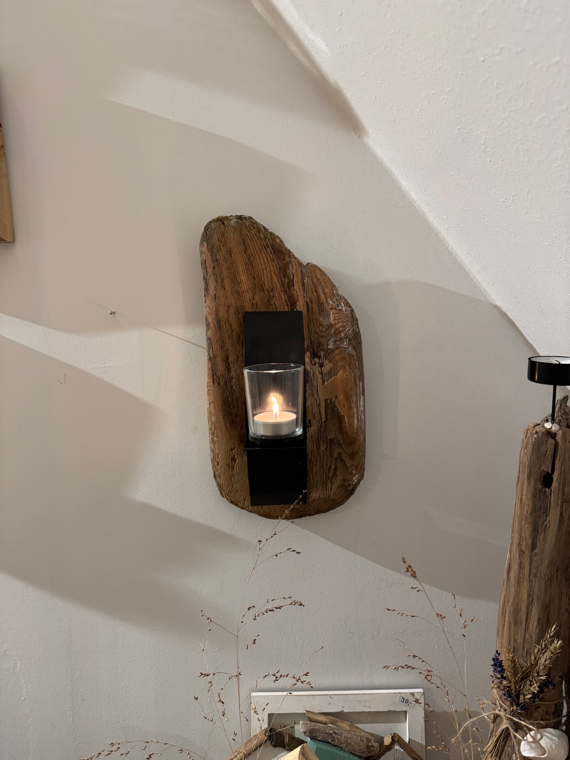 Detailansicht Treibholz Kerzenhalter an der Wand, rustikale Holzmaserung und Glas mit Kerze