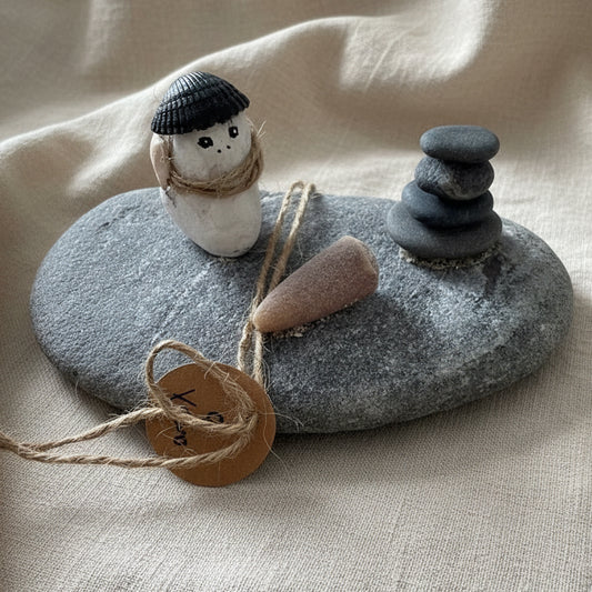 Detailaufnahme Steinfigur mit Muschel, Naturband und Donnerkeil aus echten Strandfunden