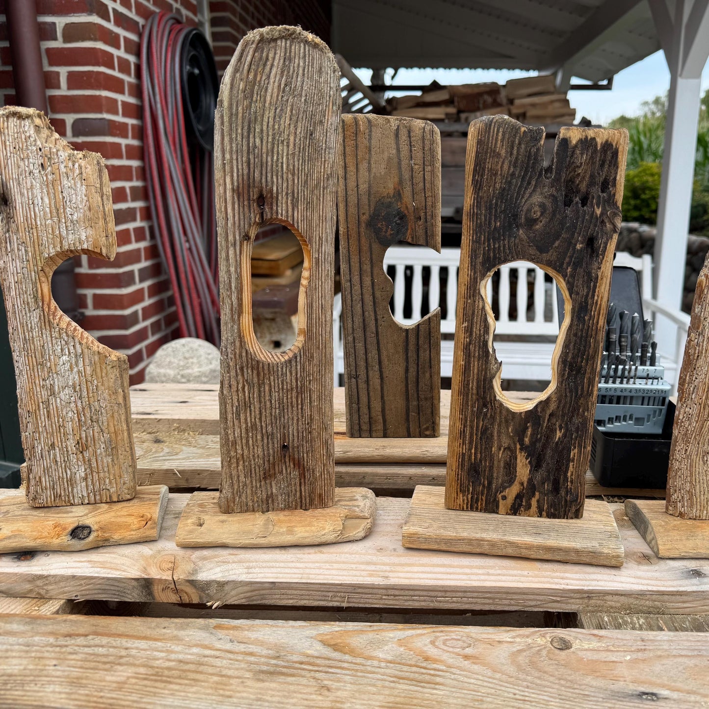 Eine Sammlung rustikaler Holzskulpturen mit verschiedenen ausgeschnittenen Formen, darunter ein Herz und ein Oval.