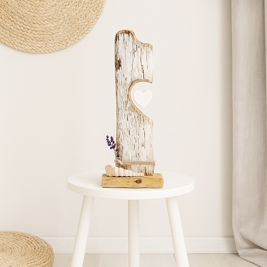 Treibholz Skulptur mit Herz, dekoriert mit Lavendel und Muscheln, präsentiert auf einem weißen Hocker.