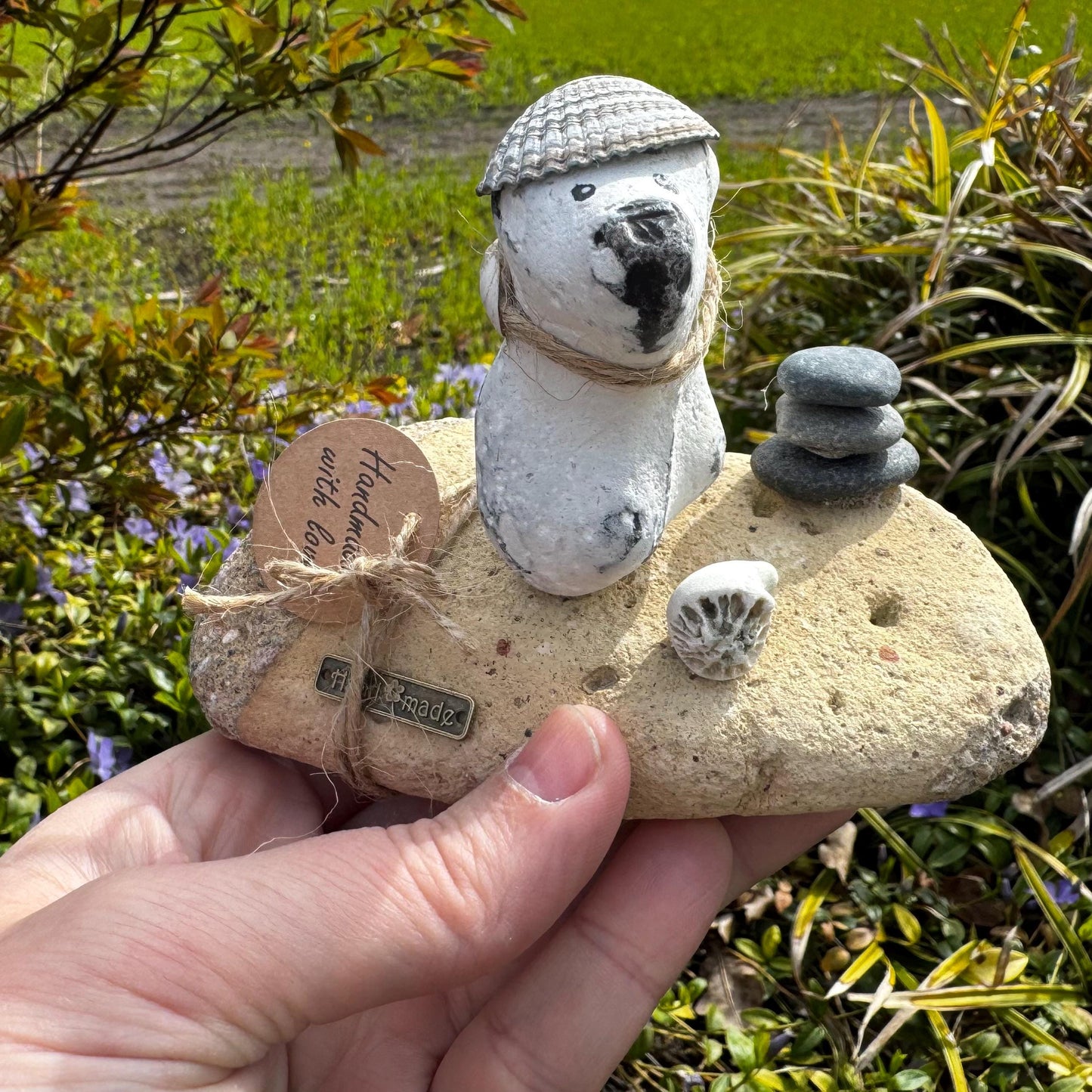 Maritime Steinfigur Hund mit Muschel und gestapelten Steinen im Garten fotografiert, nordische Küstendeko handgemacht