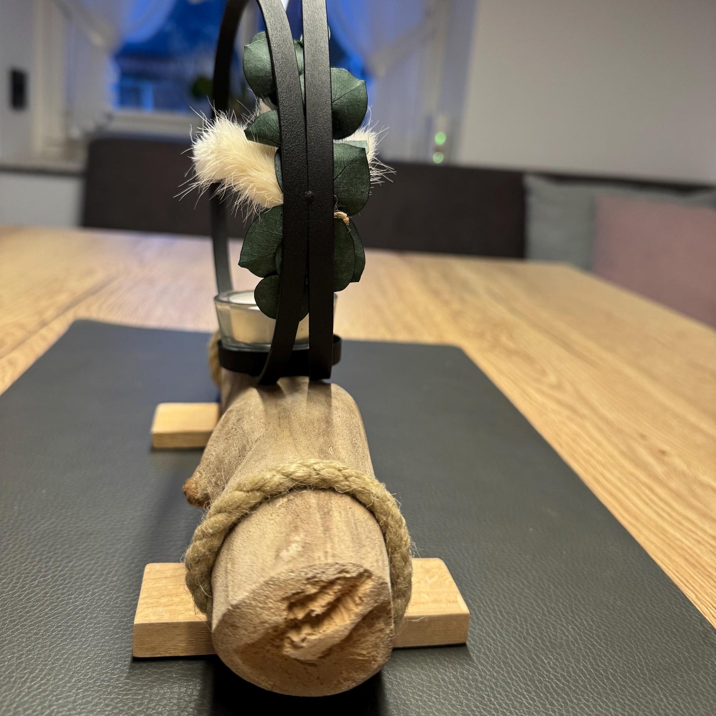Seitliche Ansicht eines kleinen Kerzenhalters aus Treibholz mit schwarzem Metallring und Glas-Teelichthalter