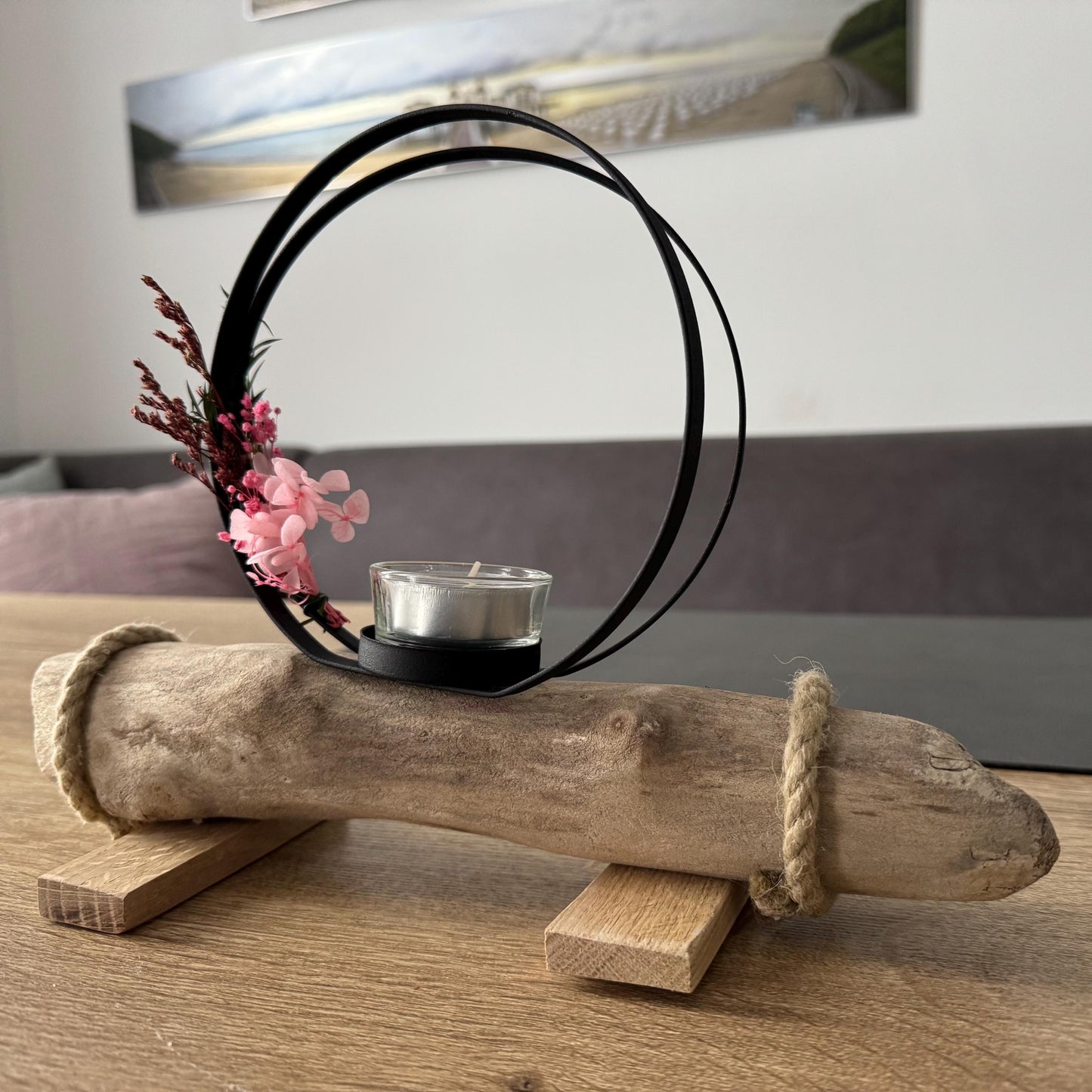 Skandinavische Wohnzimmerdeko mit kleinem Kerzenhalter aus Treibholz auf hellem Holztisch, maritime Küstendeko