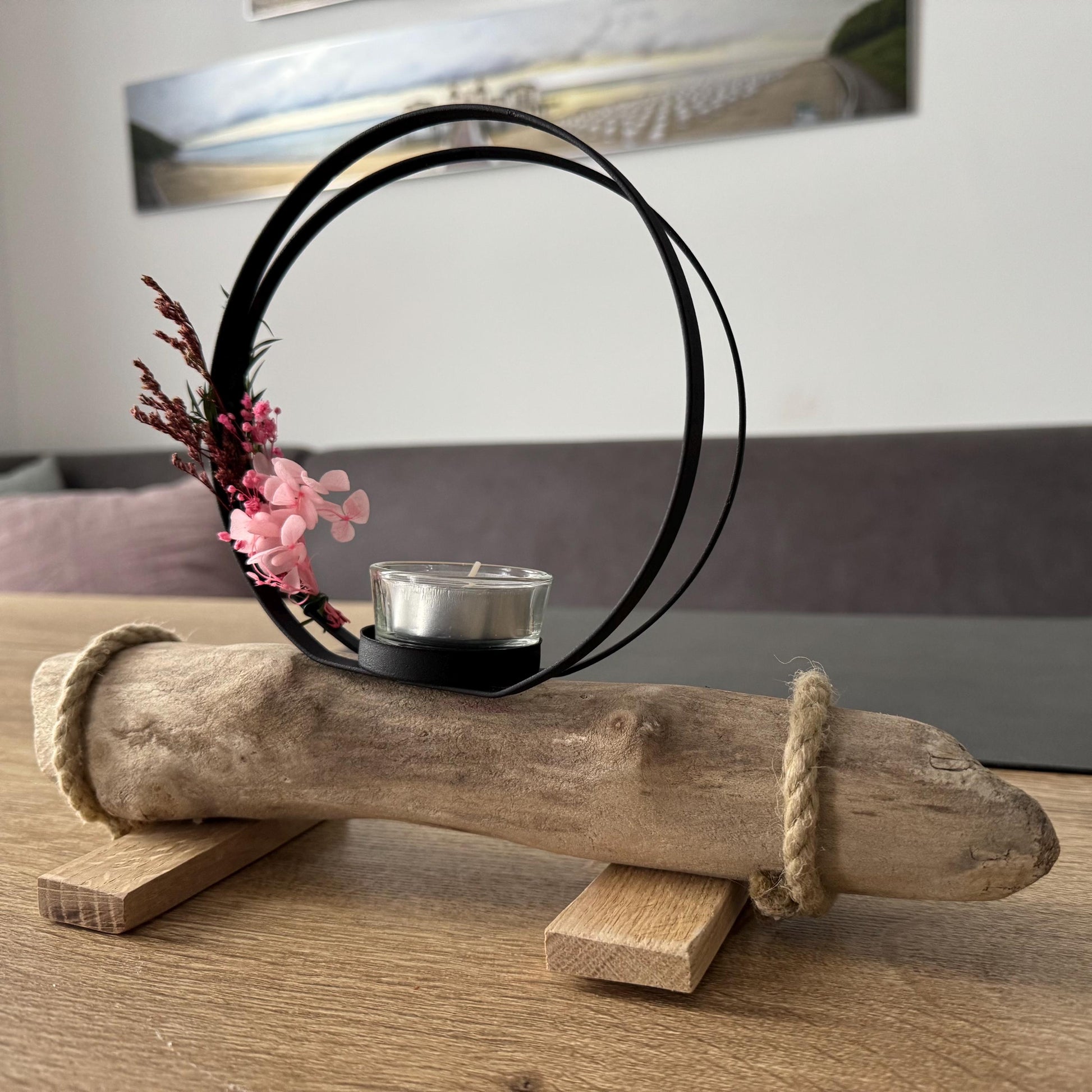 Skandinavische Wohnzimmerdeko mit kleinem Kerzenhalter aus Treibholz auf hellem Holztisch, maritime Küstendeko