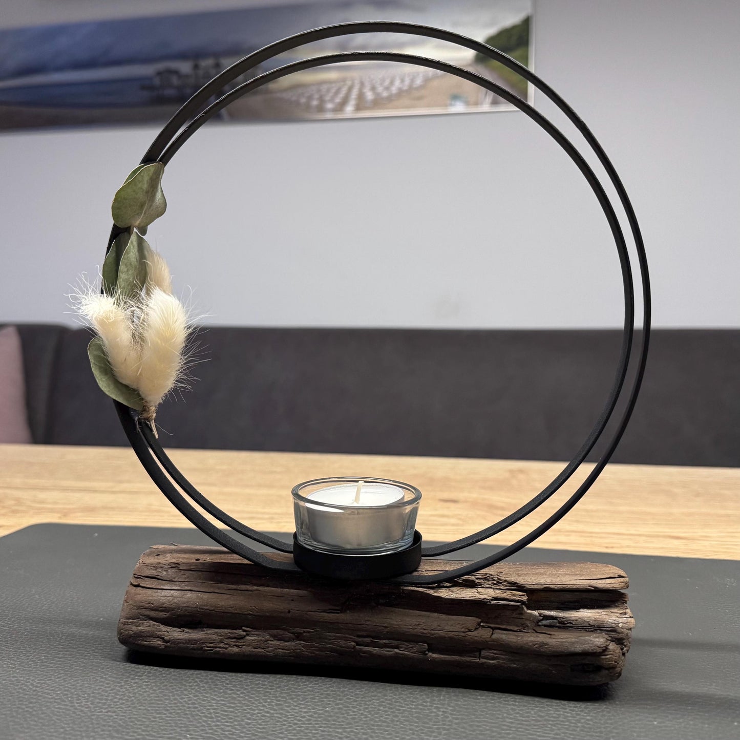 Skandinavische Wohnzimmerdeko mit Kerzenhalter aus Treibholz auf hellem Holztisch, nordische maritime Einrichtung