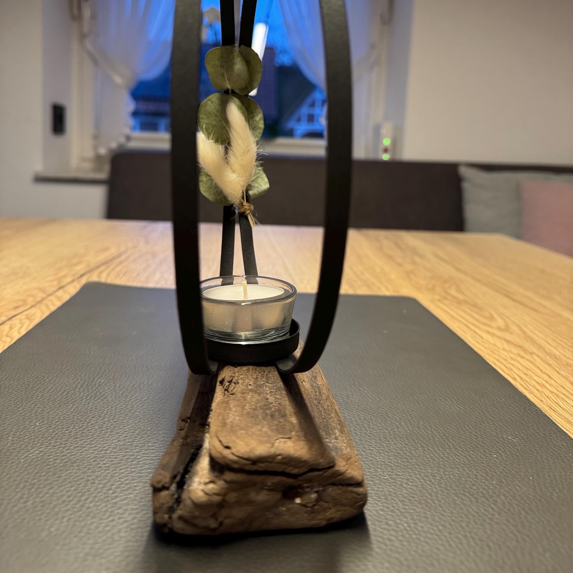 Seitliche Ansicht eines handgefertigten Kerzenhalters aus Treibholz mit schwarzem Metallring und Glas-Teelichthalter