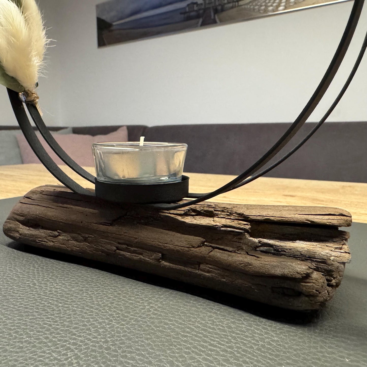 Detailaufnahme vom Metallring mit Eukalyptus und Lagurus an einem handgefertigten Kerzenhalter aus Treibholz, natürliche Küstendeko