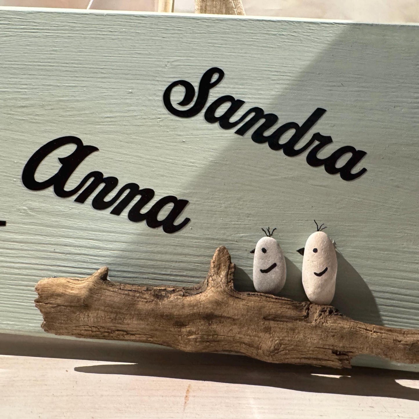 Hellblaues Holzschild mit den Namen "Anna" und "Sandra" in schwarzer Schrift von Treibholzzauber79