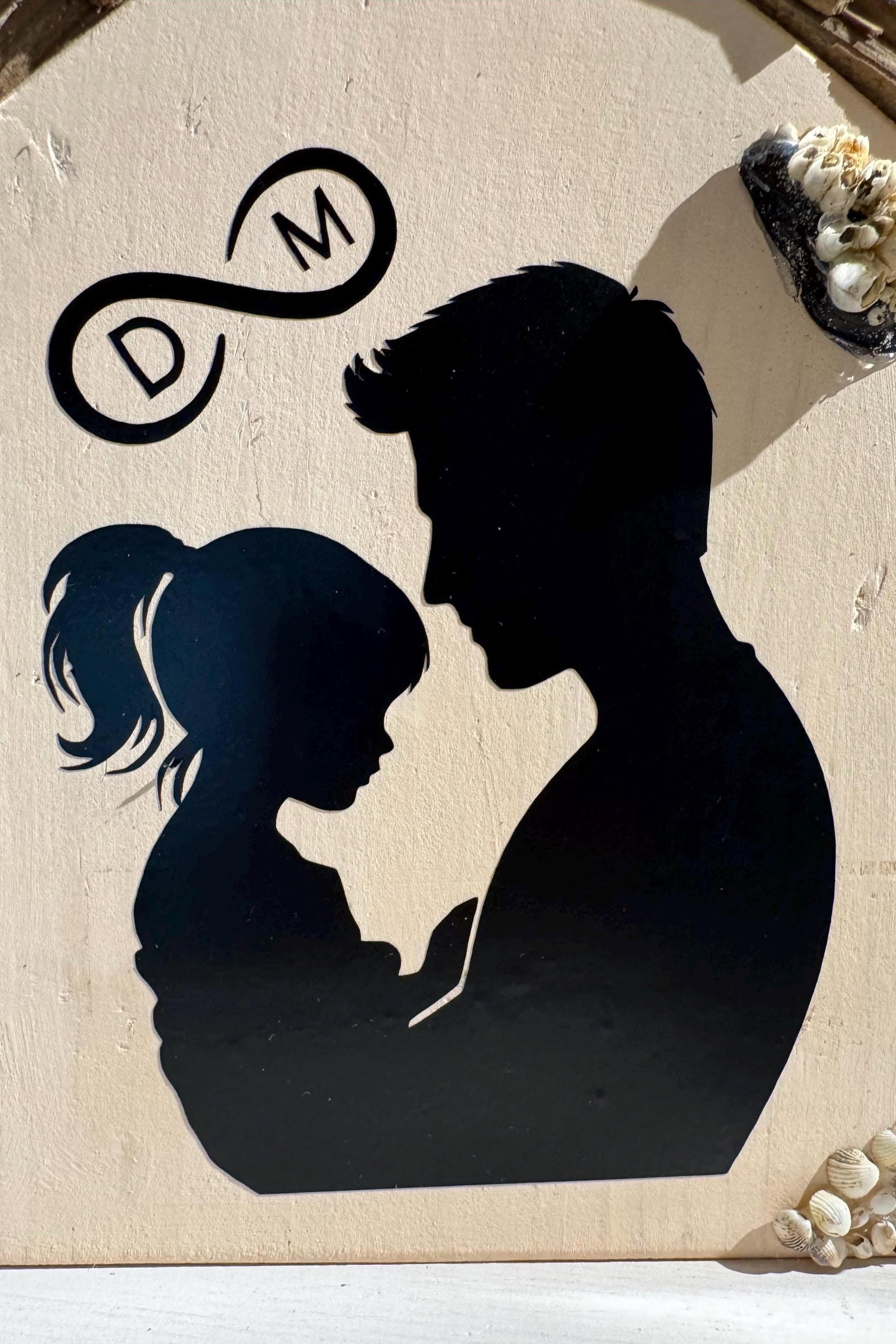 Detailaufnahme der Papa-und-Kind-Silhouette auf handgefertigtem Holzhaus von Treibholzzauber79