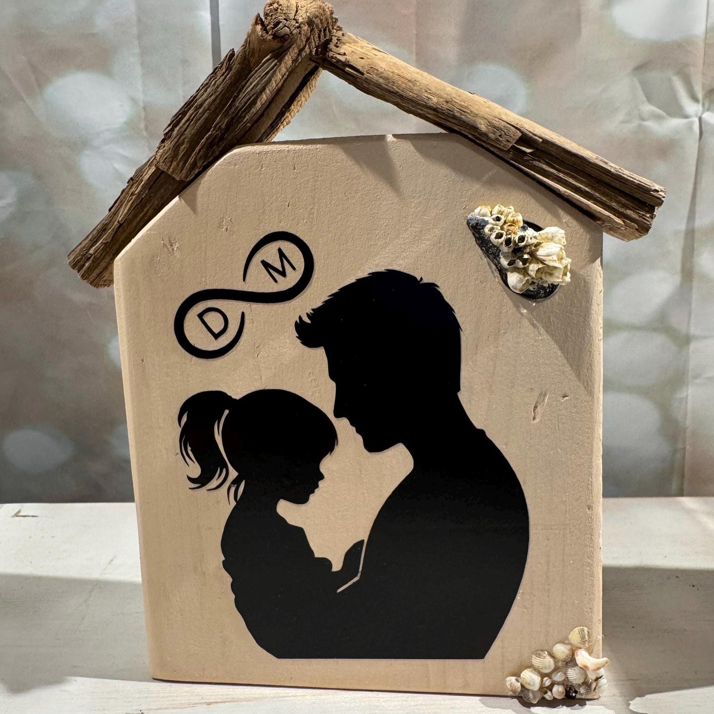 Beige Holzdekoration in Hausform mit einem Treibholz-Dach von Treibholzzauber79 mit Vater & Kind auf der Vorderseite