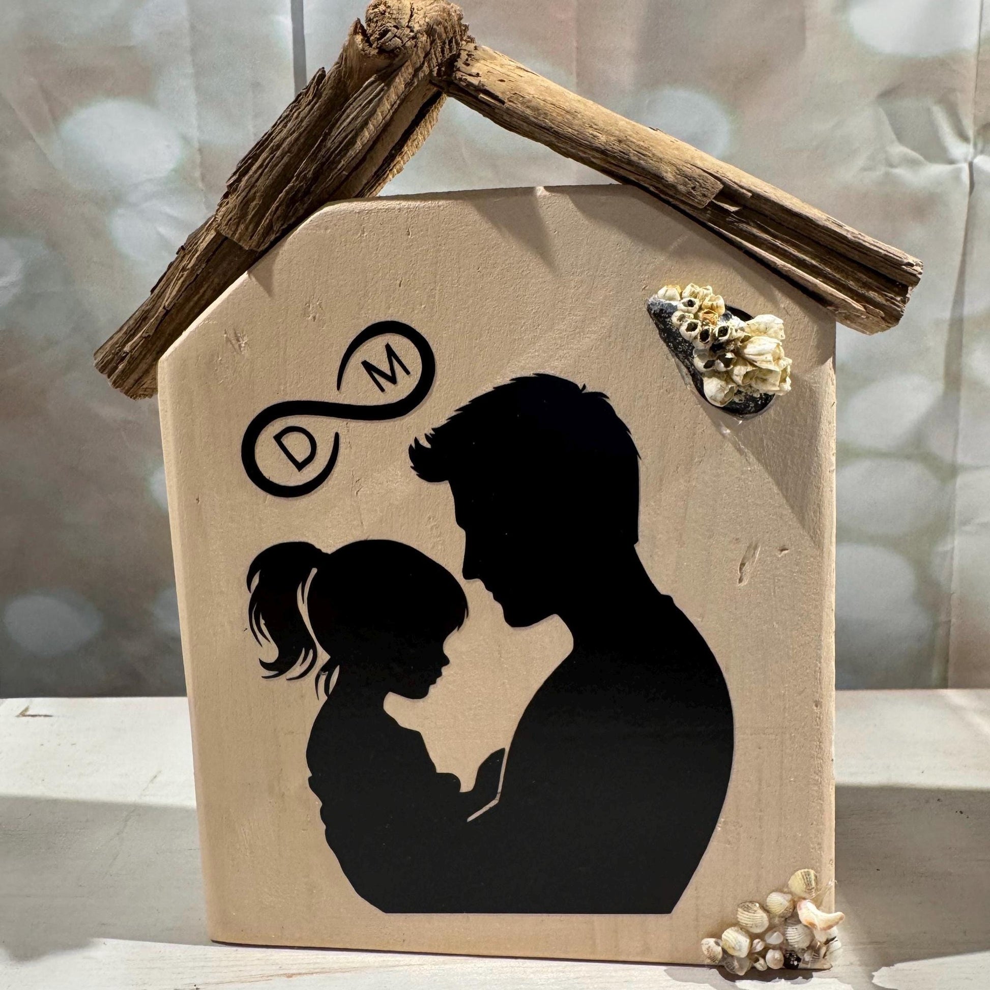 Beige Holzdekoration in Hausform mit einem Treibholz-Dach von Treibholzzauber79 mit Vater & Kind auf der Vorderseite