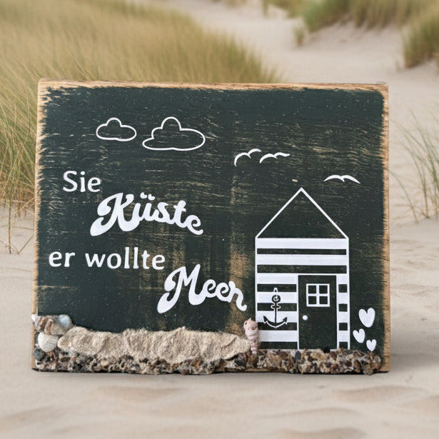 Handgemachte Treibholz Häuser aus Eiche mit Küstenmotiv und Spruch in einer Düne, dekoriert mit Muscheln