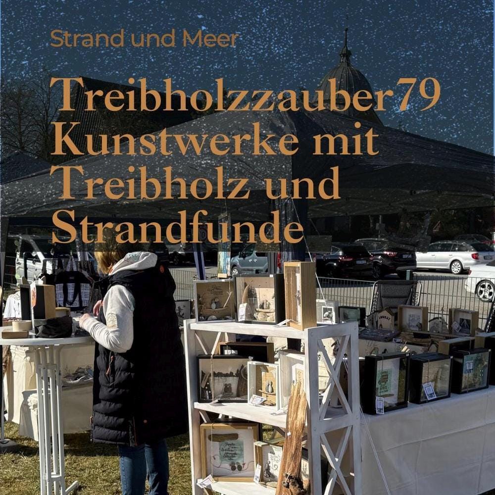Ein Marktstand im Freien mit gerahmten Kunstwerken und Dekorationsartikeln von Treibholzzauber79