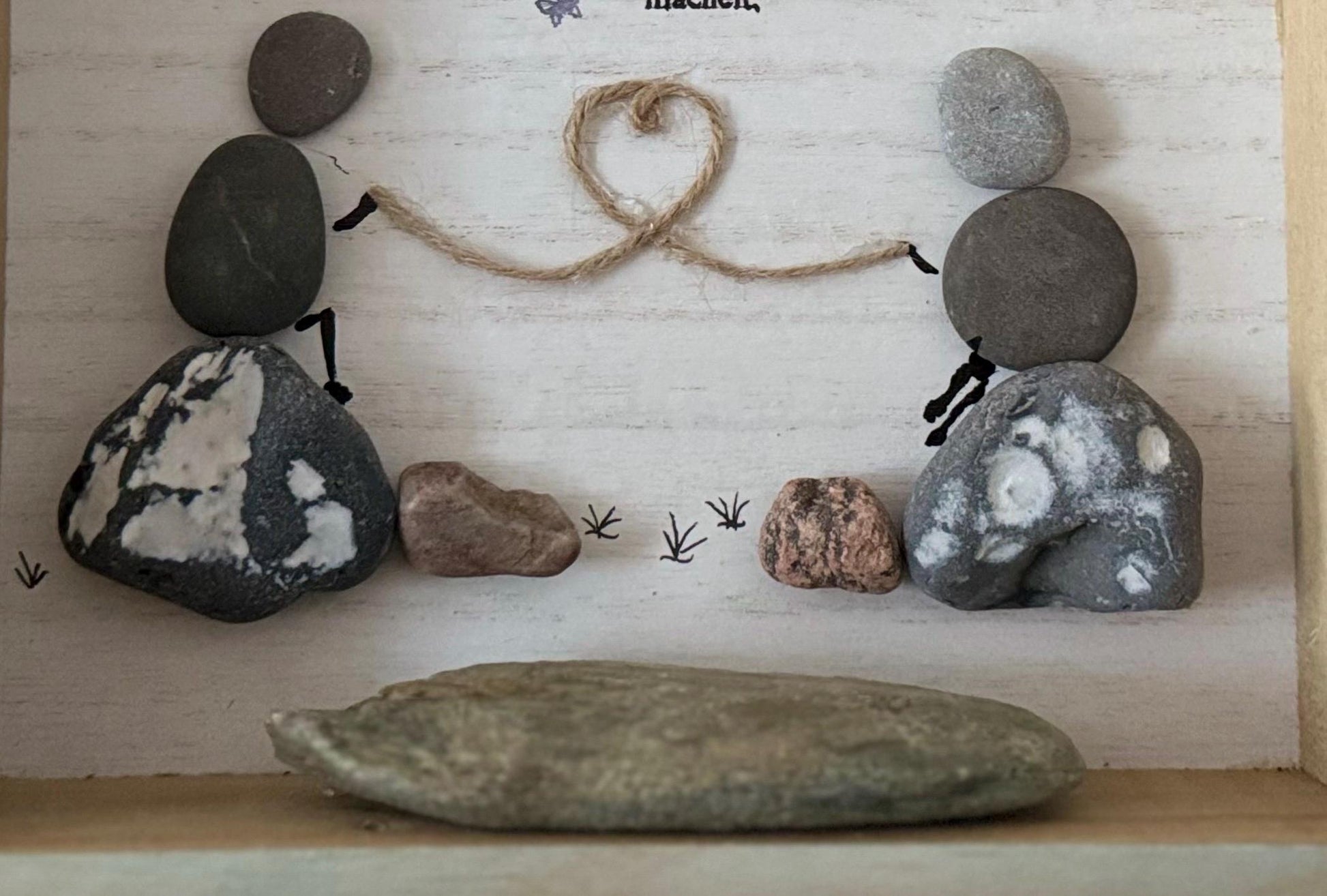 Detailansicht von handgemachtes Steinbild personalisiert im weißen Holzrahmen.