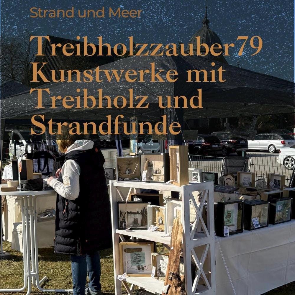 Maritimes Holzhäuschen mit Möwe, Fehmarnsundbrücke und Steinrand - gehalten in einer Hand vor heller Deko.