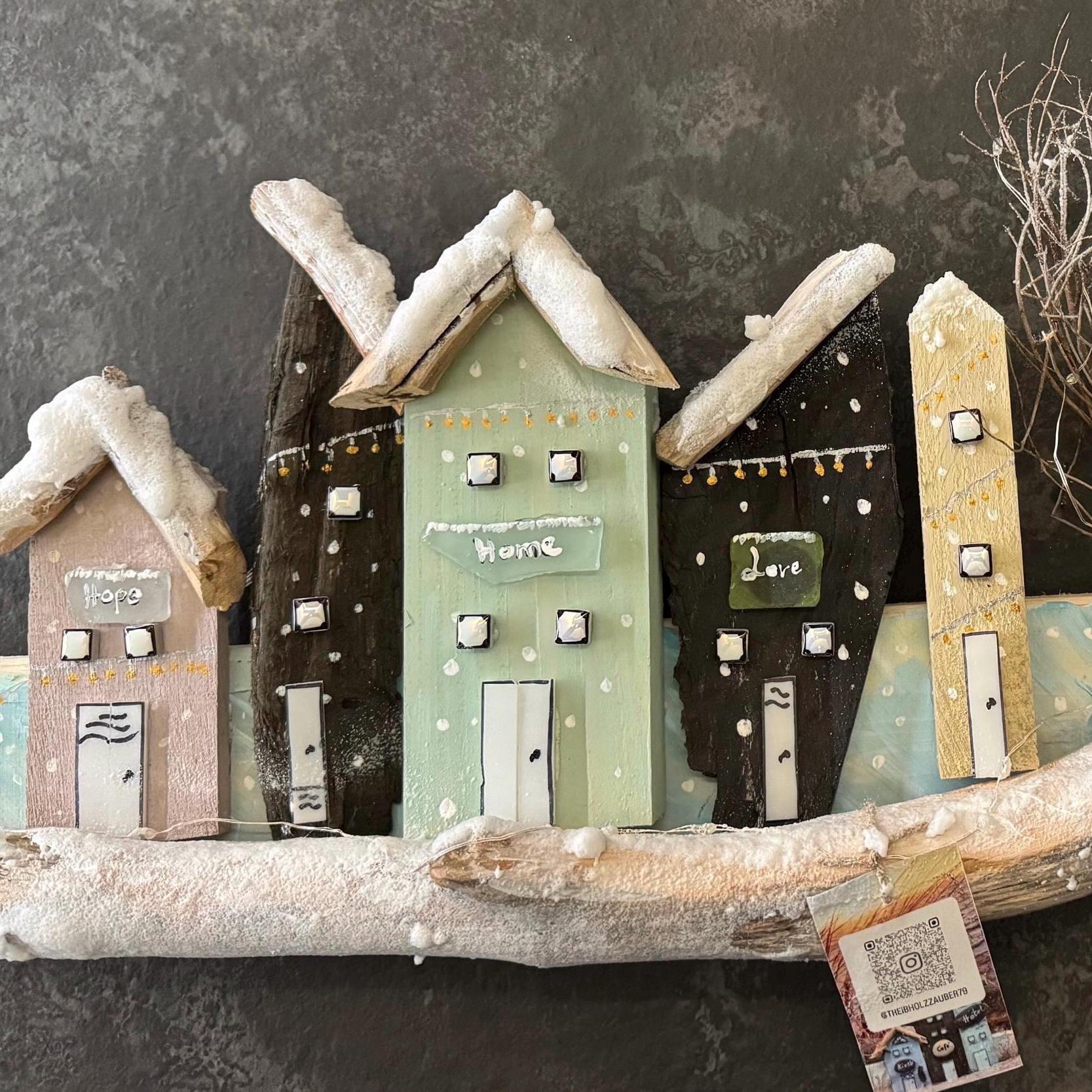 Ein rustikales Holz-Kunstwerk mit fünf Miniaturhäusern mit schneebedeckten Dächern von Treibholzzauber79