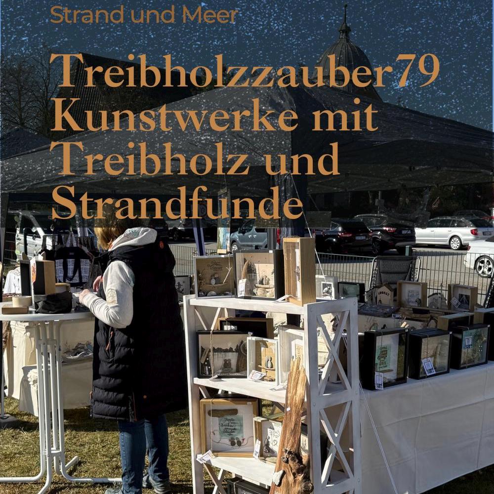 Ein Marktstand im Freien mit gerahmten Kunstwerken und Holzhandwerk. Der Text "Strand und Meer" und "Treibholzzauber 79