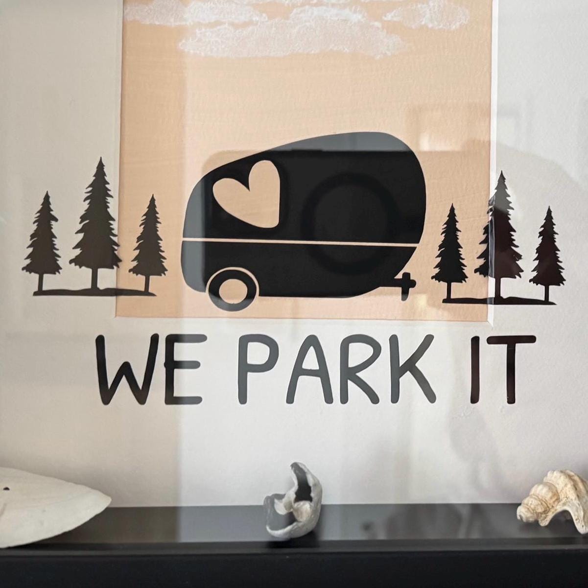 Nahaufnahme Camper Silhouette und Schriftzug Home is where we park it im Bilderrahmen  von Treibholzzauber79