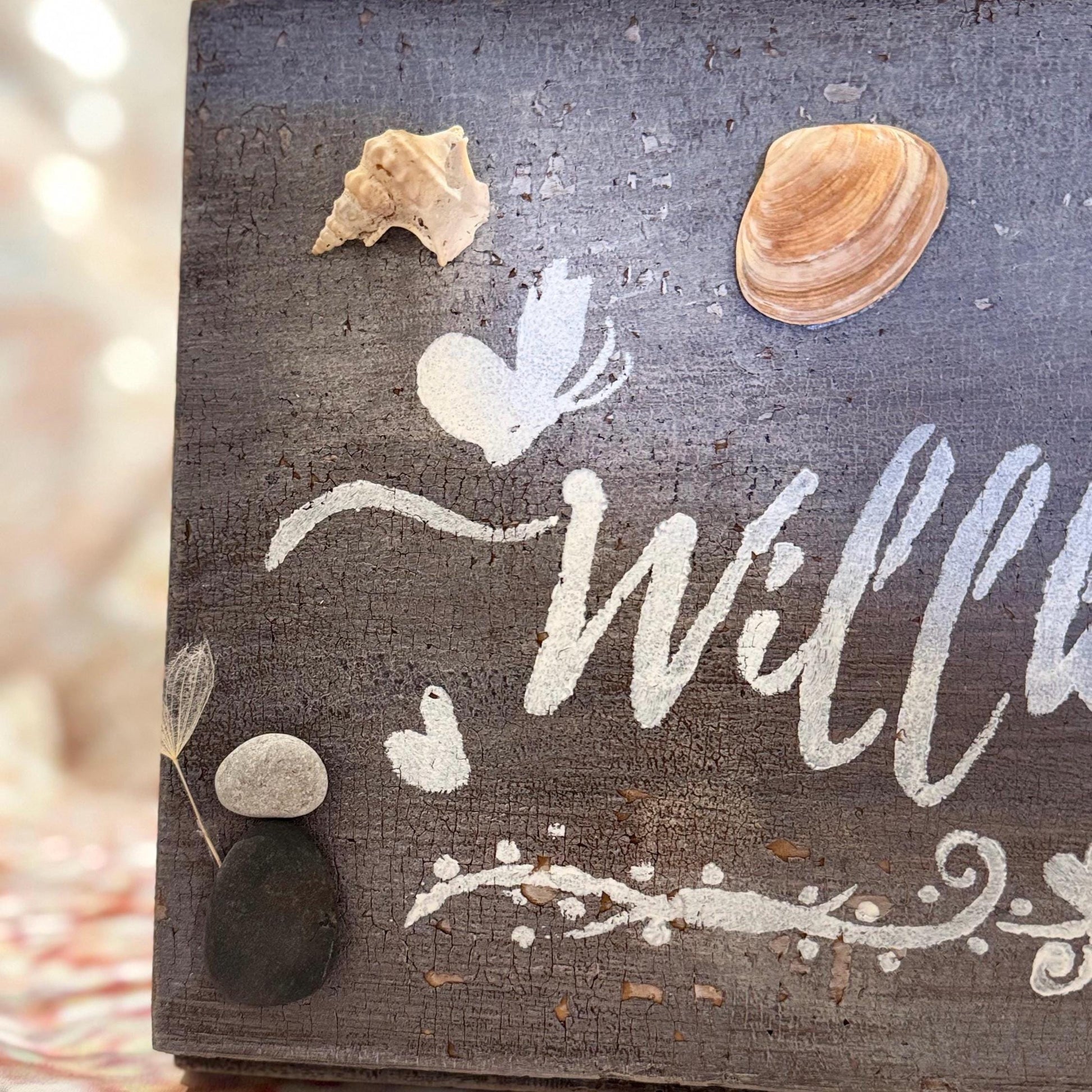 Ein verwittertes Holzschild mit dem Wort "Welcome" in weißer Schrift von Treibholzzauber79