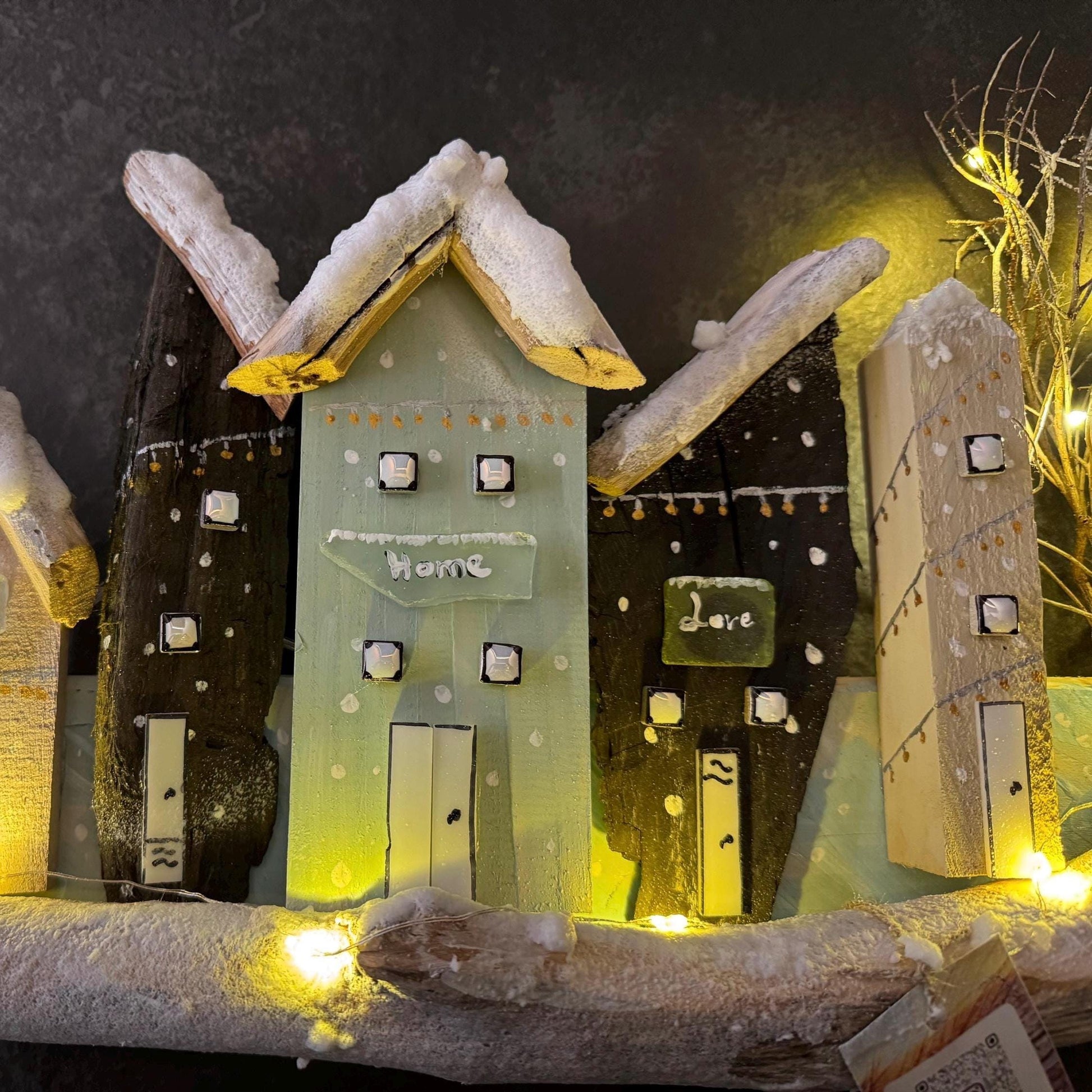 Eine dekorative Holz-Dorfszene mit mehreren kleinen Häusern mit schneebedeckten Dächern von Treibholzzauber79