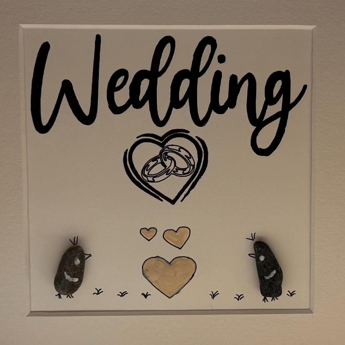 Nahaufnahme Schriftzug „Wedding“ mit Herzmotiv und kleinen maritimen Steinfiguren im Holzrahmen von Treibholzzauber79