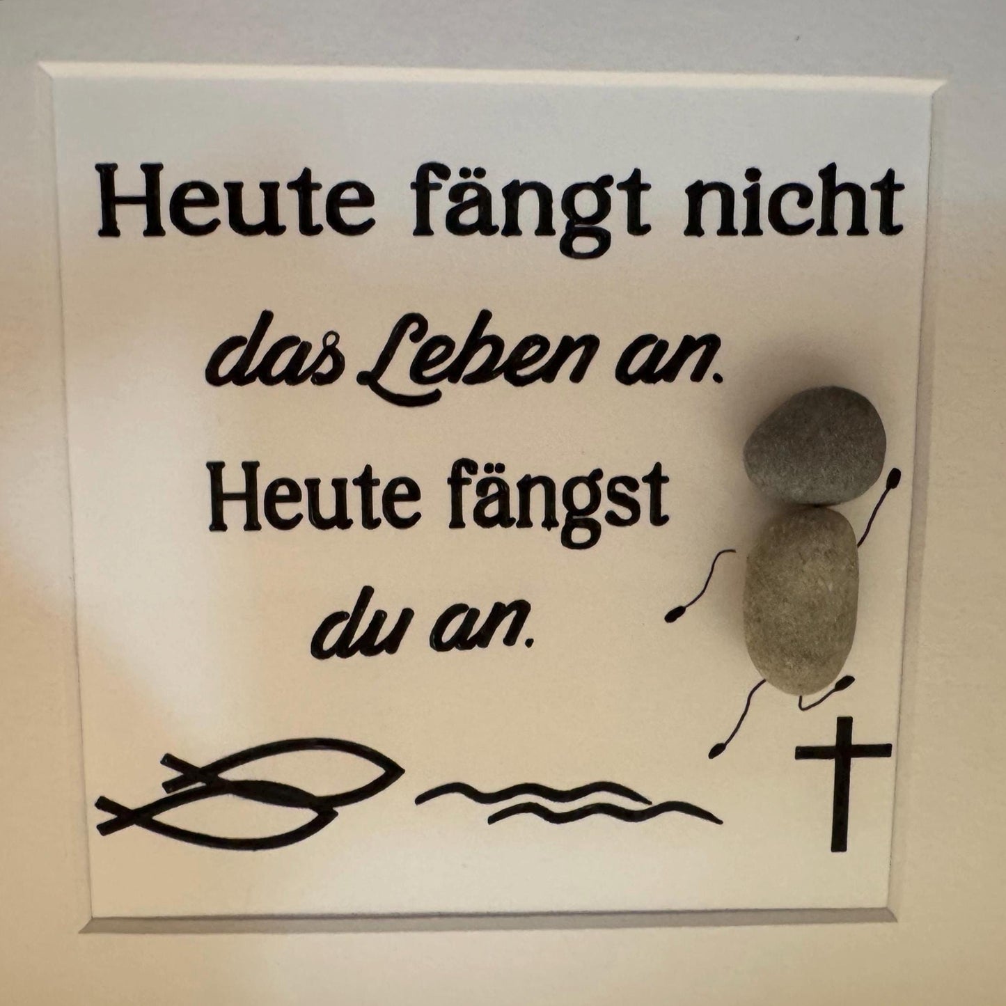 Ein weißes quadratisches Schild mit schwarzem Text: "Heute fängt nicht das Leben an. Heute fängst du an."