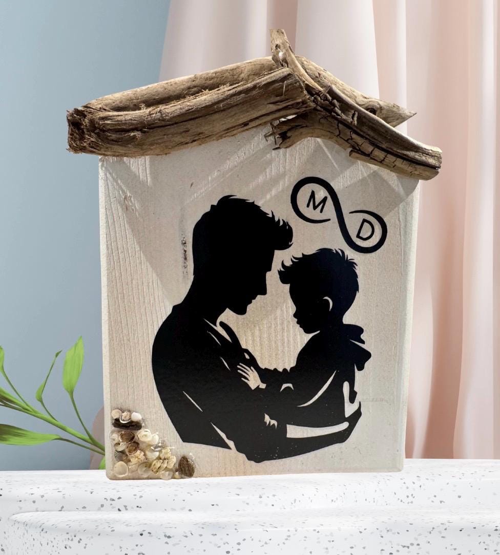 Holzhaus-Deko „Vater Sohn“ aus hellem Holz mit Treibholz-Dach; schwarze Silhouette von Vater und Sohn von Treibholzzauber79