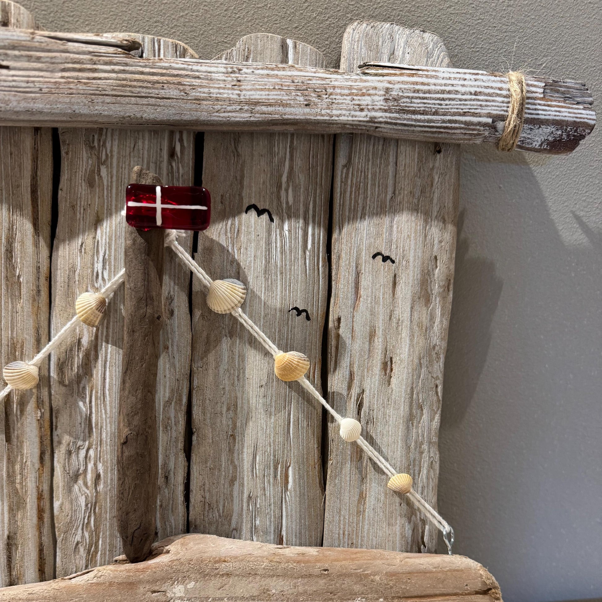 Nahaufnahme Wanddeko aus Treibholz in Naturtönen, maritim gestaltet mit kleiner Flagge und Segelmotiv von Treibholzzauber79