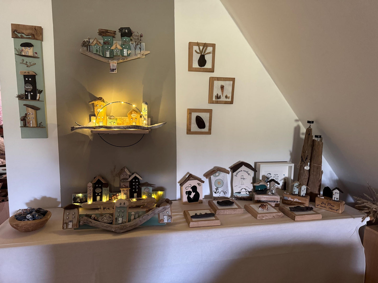 Ausstellung handgefertigter Holzkunstwerke, darunter Miniaturhäuser und gerahmte Kunstwerke. von Treibholzzauber79