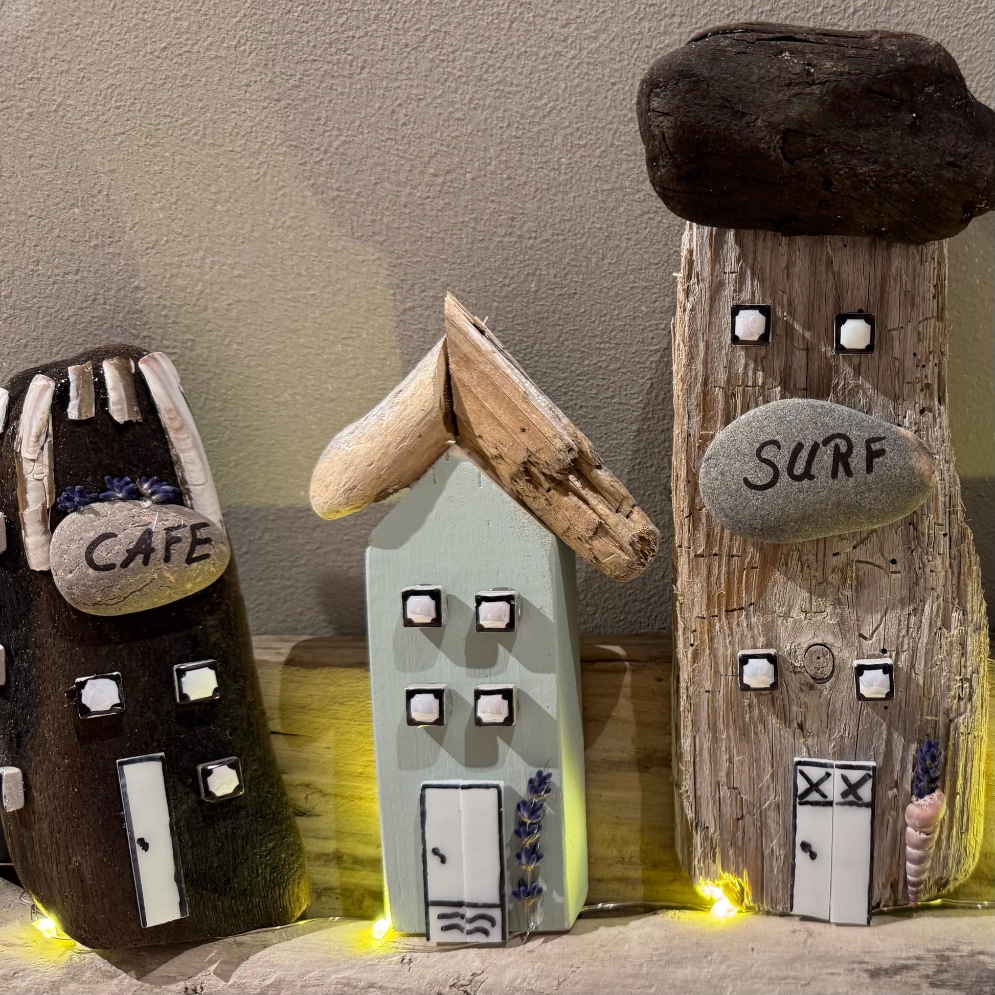 Handgemachtes Wandbild aus Treibholz – kleine Küstenhäuschen mit Café und Surfhaus, liebevoll dekoriert mit Naturmaterialien