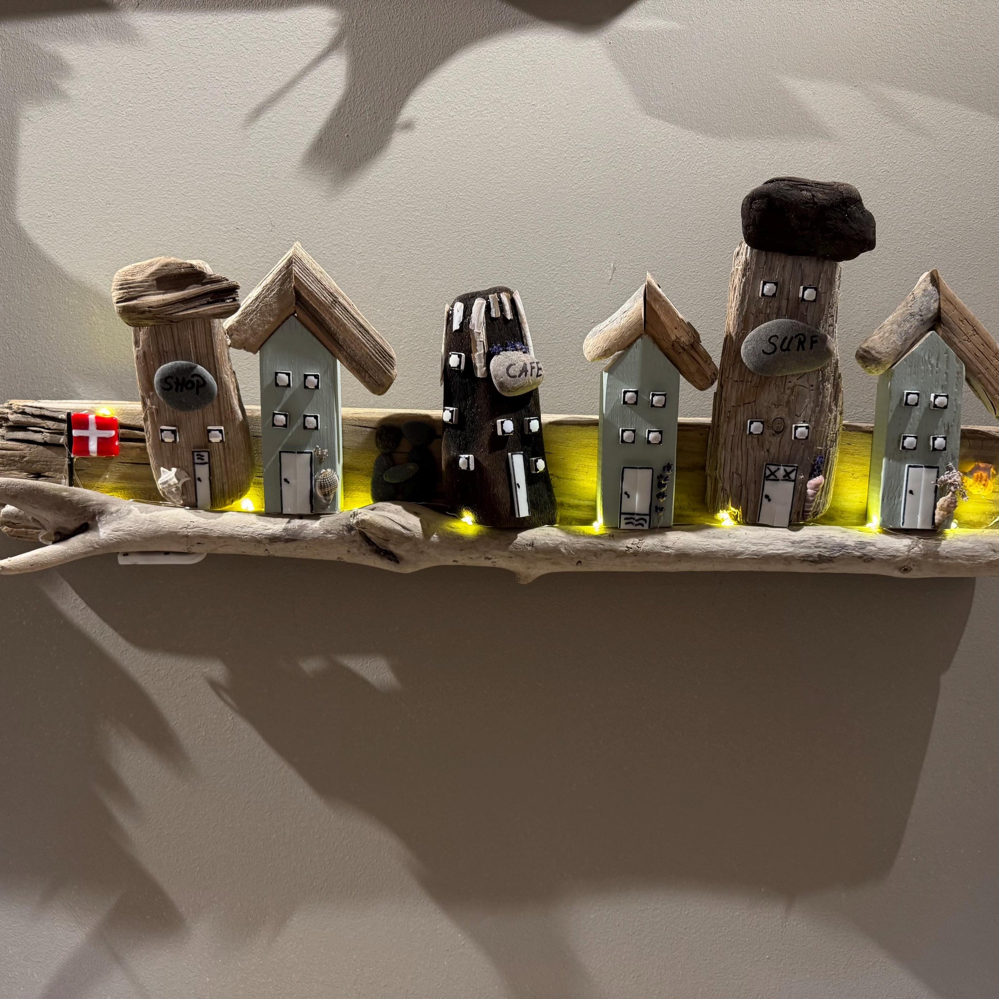 Handgemachtes Wandbild aus Treibholz – kleine Küstenhäuschen mit Café und Surfhaus, liebevoll dekoriert von Treibholzzauber79