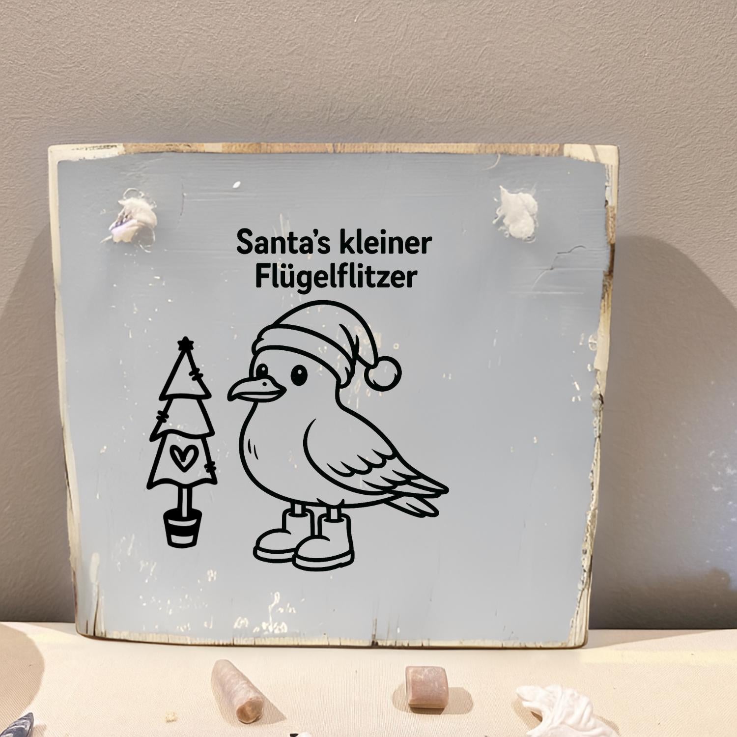 Weihnachtsdeko aus Holz, rustikales Holzschild mit dem Text "Santa's kleiner Flügelflitzer" einer Möwe mit Weihnachtsmütze