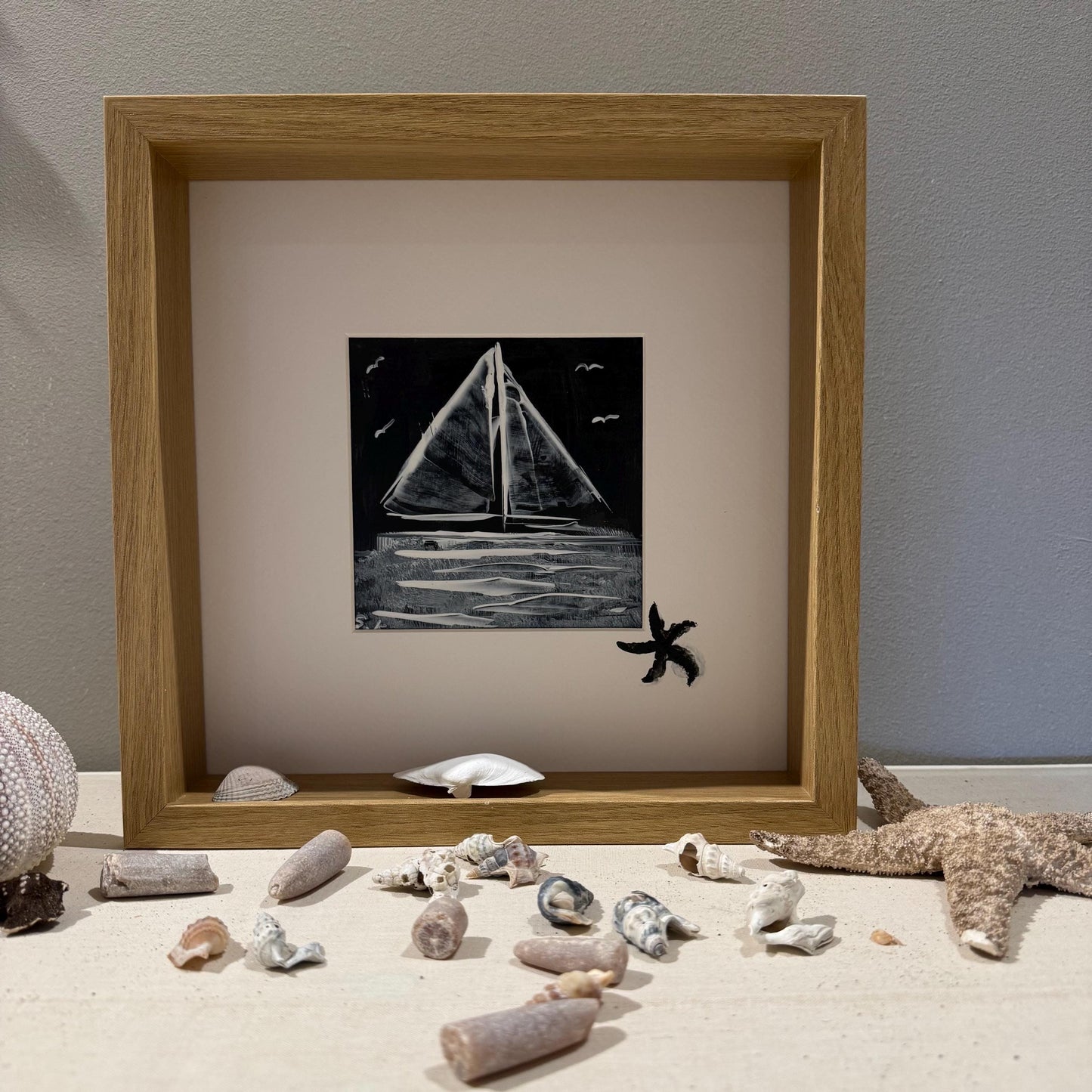 Gerahmtes Schwarz-Weiß-Gemälde eines Segelboots. Das Kunstwerk befindet sich in einem hellen Holzrahmen von Treibholzzauber79