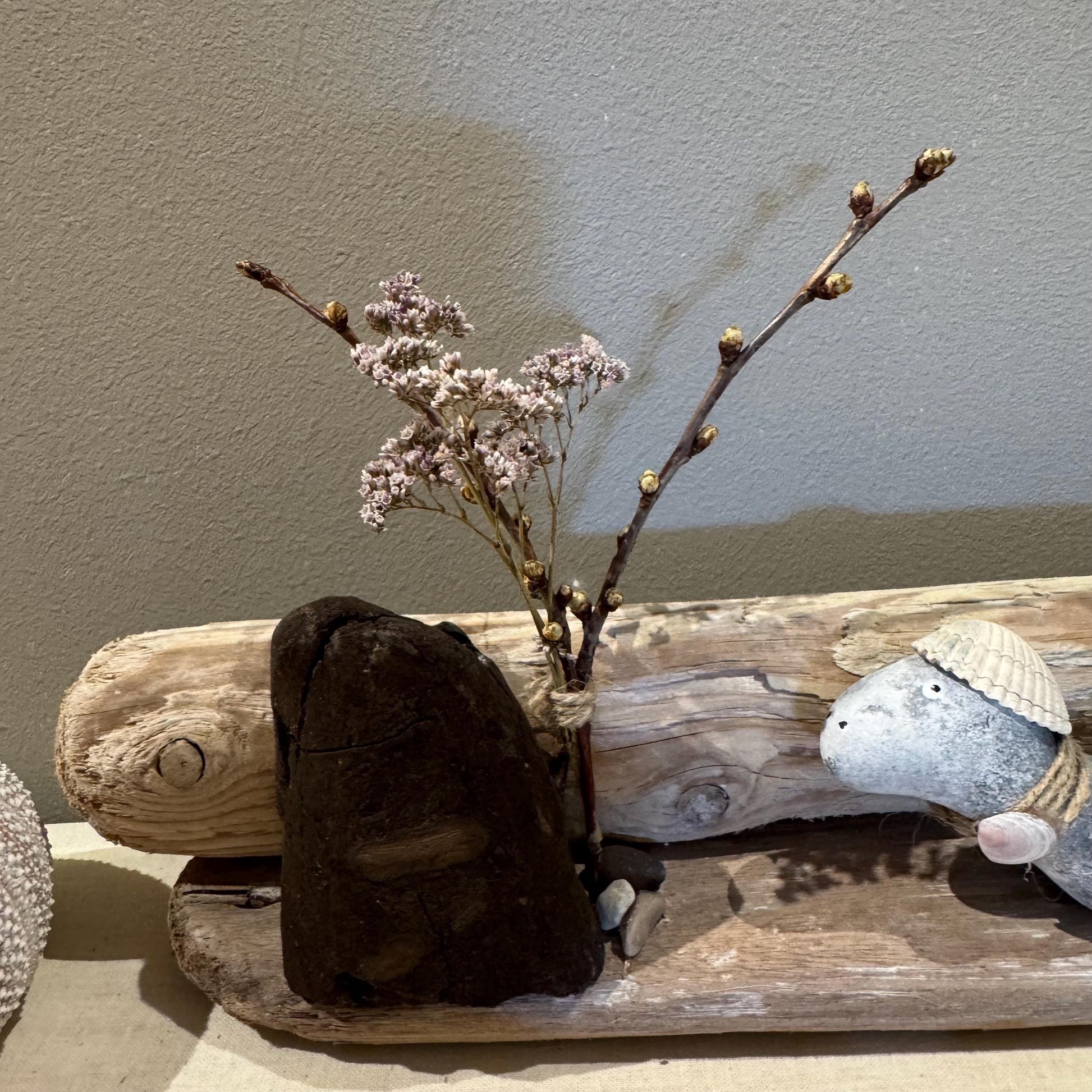 Nahaufnahme von versteinertem Holz, Donnerkeil-Fossil und Treibholzstruktur in der maritimen Handmade-Deko.