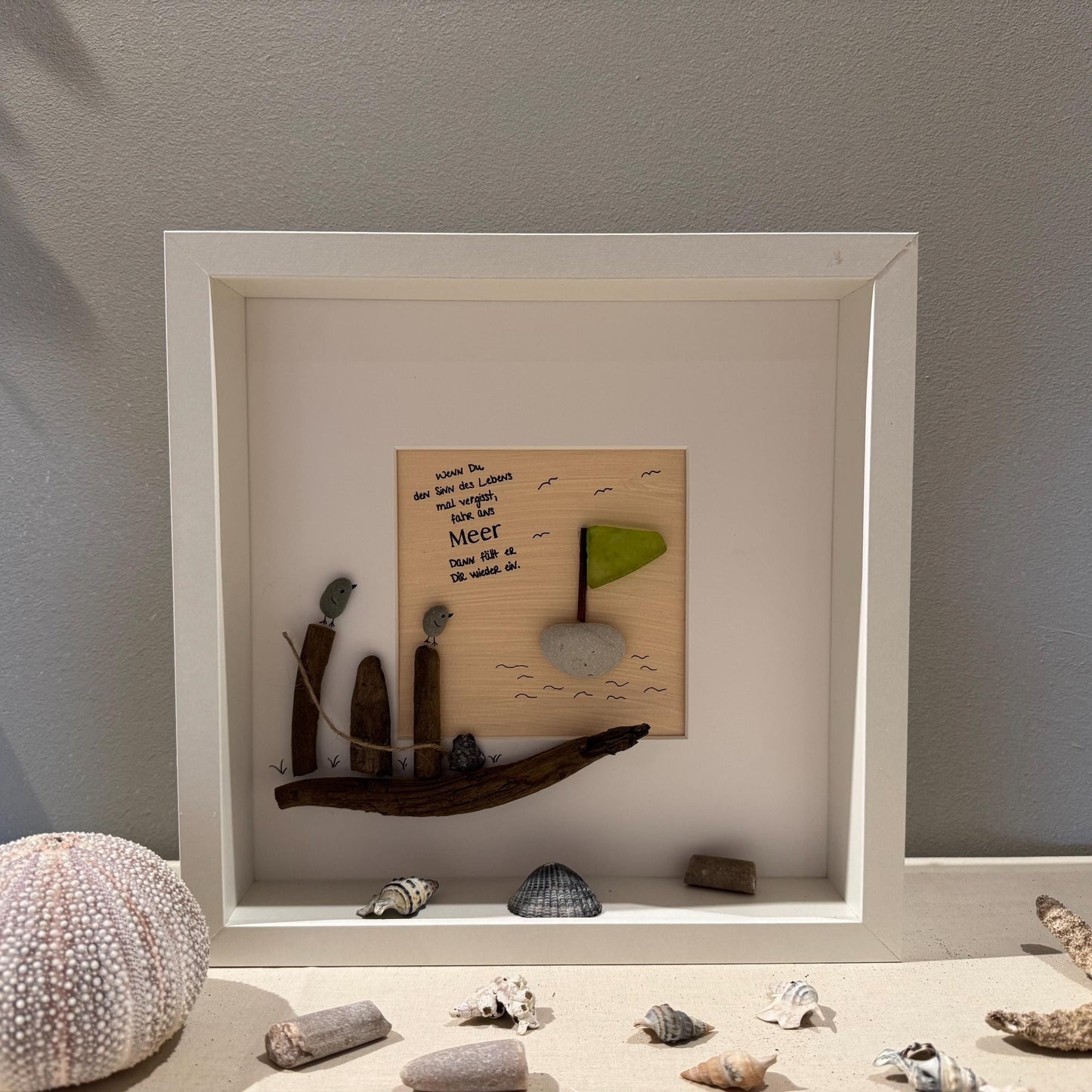 Ein gerahmtes Kunstwerk mit einem Treibholzboot mit kleinen Holzfiguren und Vögeln von Treibholzzauber79