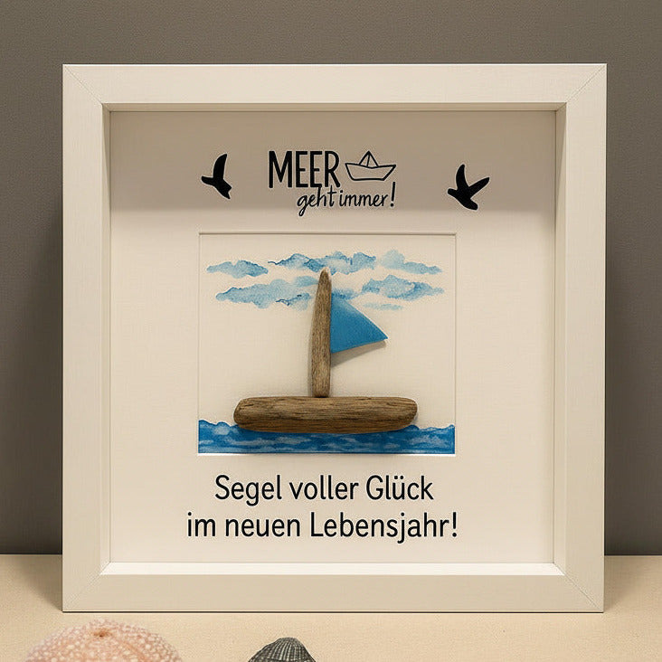 Personalisiertes Steinbild Segelboot aus Treibholz und einer Fahne vor einem gemalten Himmel mit Wolken und Vögeln.
