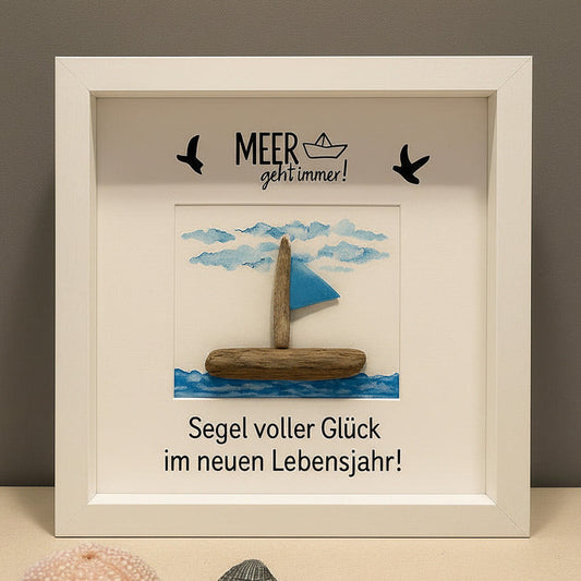 Personalisiertes Steinbild Segelboot aus Treibholz und einer Fahne vor einem gemalten Himmel mit Wolken und Vögeln.