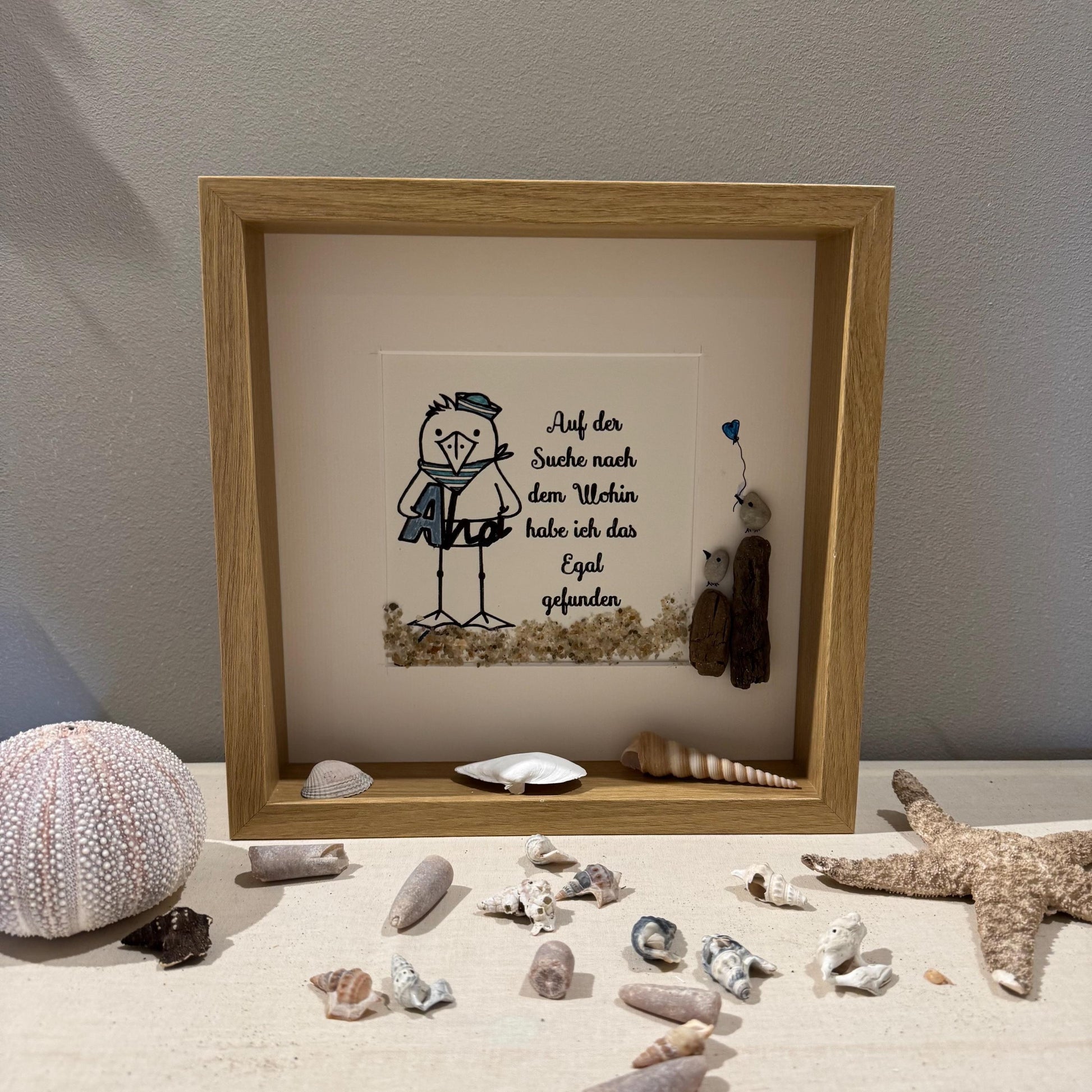 Ein gerahmtes Kunstwerk mit einem hellen Holzrahmen. Das Kunstwerk zeigt einen Cartoon-Vogel mit Matrosenmütze