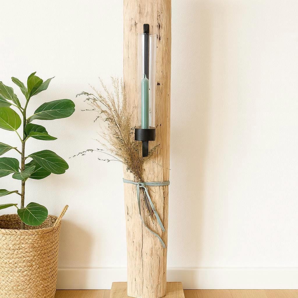 Rustikaler Kerzenhalter aus Holz mit einem schwarzen Metallrahmen, der eine teal-farbene Kerze in einem Glasrohr hält.