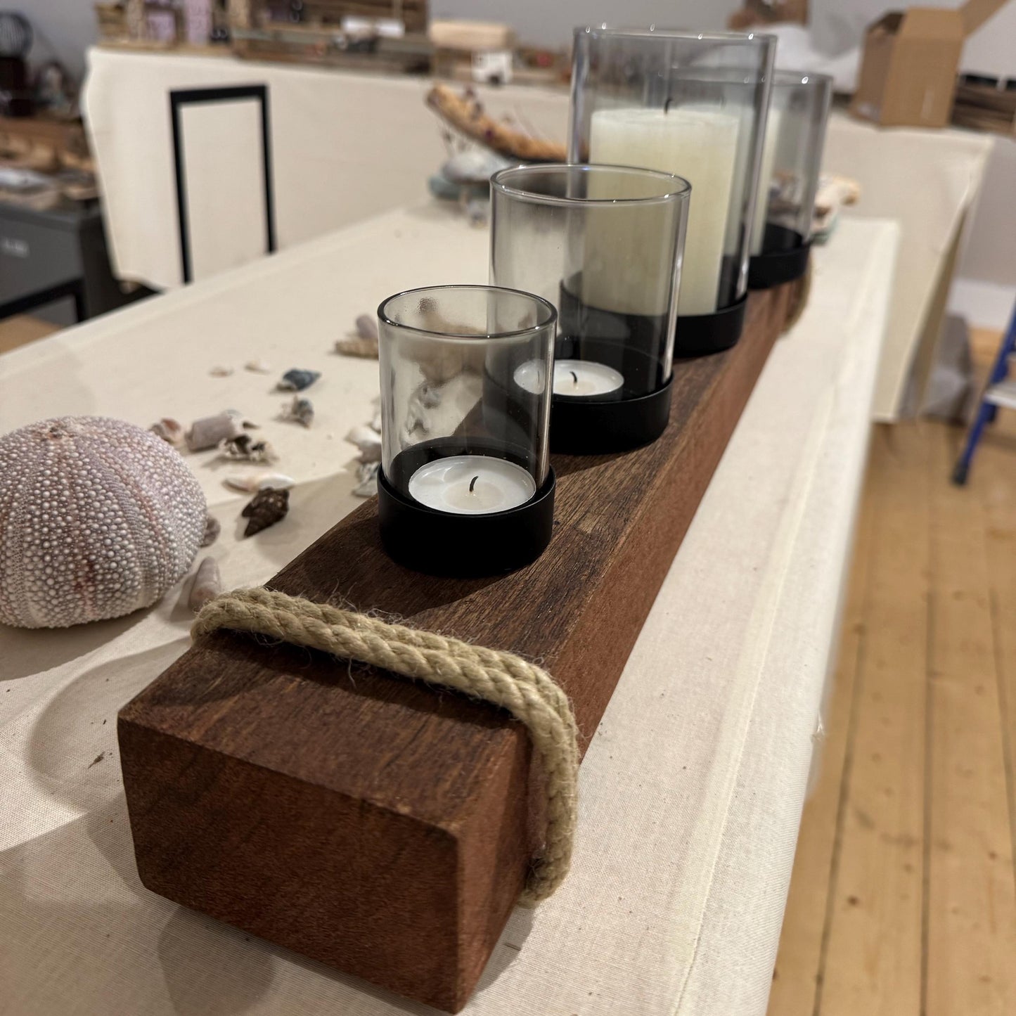 Ein rustikaler Kerzenhalter aus Holz mit vier Glas-Teelichthaltern und einem dicken Seilakzent von Treibholzzauber79